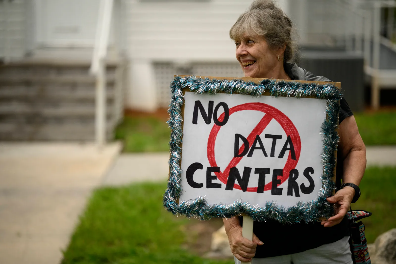 A woman holds a sign during a nationwide protest against AI data center expansion, outside Peace Hall in New Port Richey, Florida, on July 18. (Photo by Thomas Simonetti/AFP via Getty Images)