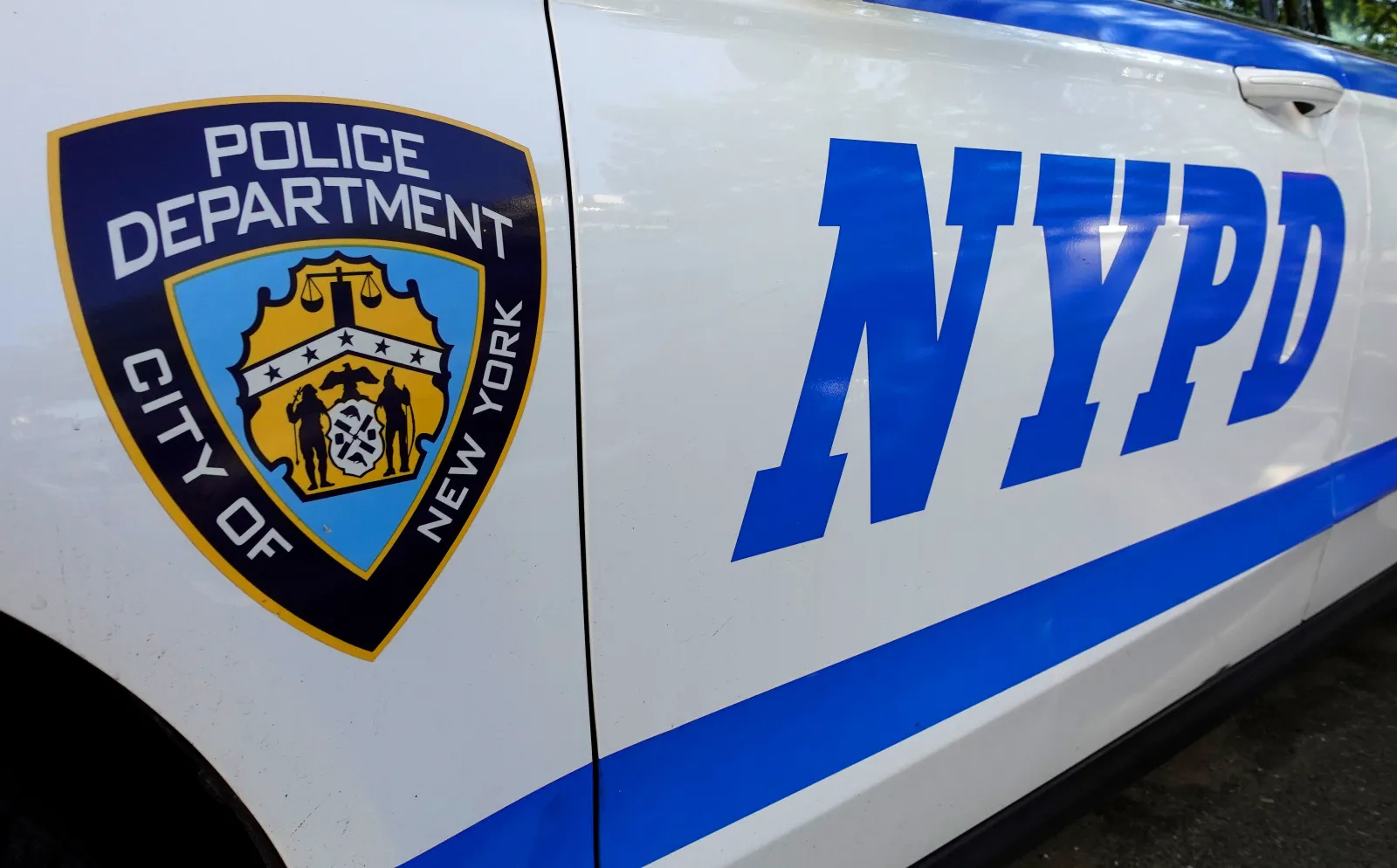 A logo for the NYPD is displayed on the side of a patrol car outside the 1st Precinct on July 20, 2026, in New York City.