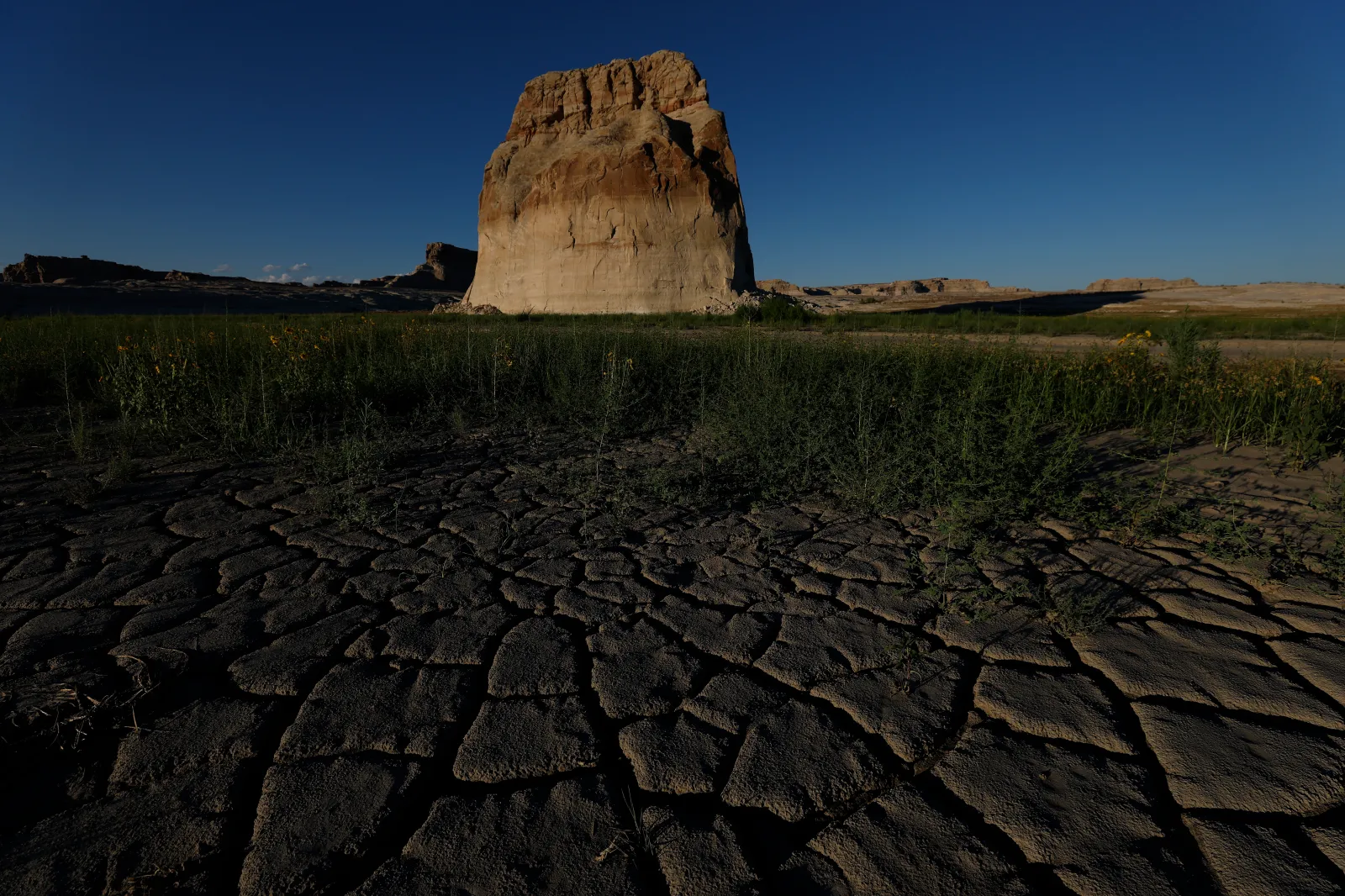 Dry cracked earth is visible in a section of Lake Powell that was previously underwater at Lone Rock Beach on July 31, 2026 in Big Water, Utah. In July, the combined water of Lake Mead and Lake Powell, the country's two biggest reservoirs, fell to their lowest levels since 1957. The unprecedented low in combined storage prompted the U.S. Department of the Interior to mandate twenty percent cuts in water usage for the next two years for Arizona, California and Nevada. Seven U.S. states and Mexico depend on the Colorado River Basin, which supplies water to more than 35 million people and is the water source for Lake Powell and Lake Mead. (Photo by Justin Sullivan/Getty Images)
