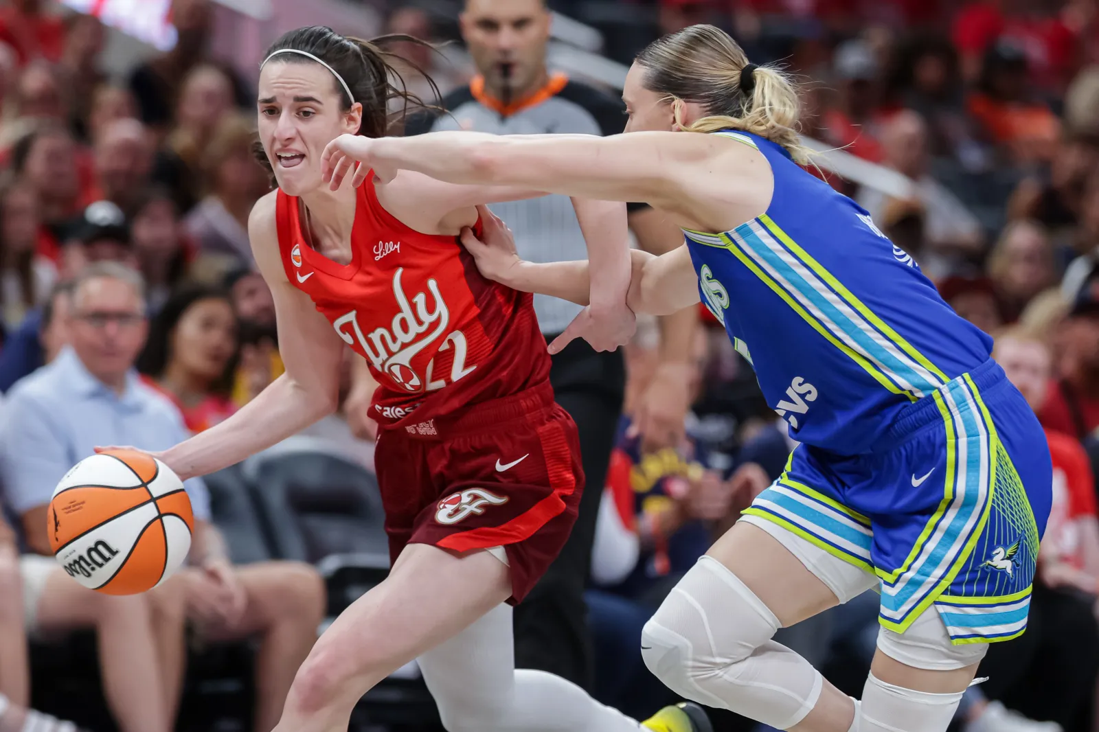Caitlin Clark drives against Paige Bueckers in Fever game against Wings