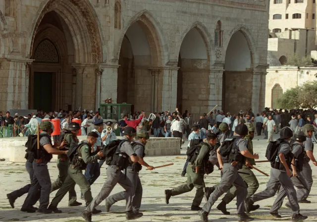 Israeli troops run as clashes erupt outside the Al-Aqsa Mosque compound in Jerusalem's Old City 28 September 2000, following a visit to the holy site by Israeli right-wing opposition leader Ariel Sharon.