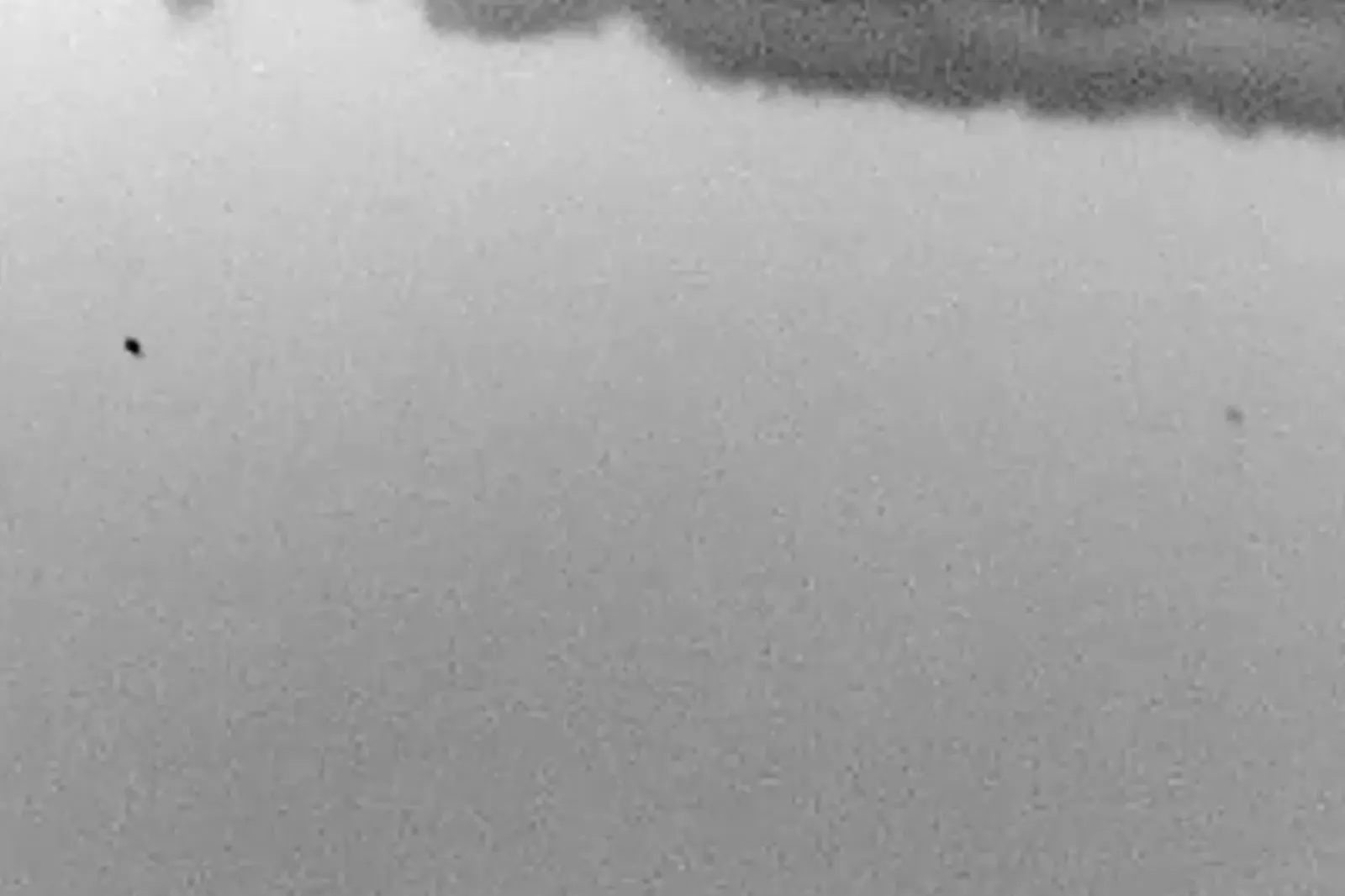 Screenshot of video captured by a U.S. Government Special Agent via hand-held optical thermal imaging device during a 2026 incident in the western United States. The footage features two, slow-moving "black-hot" areas of contrast, visible in infrared imaging.