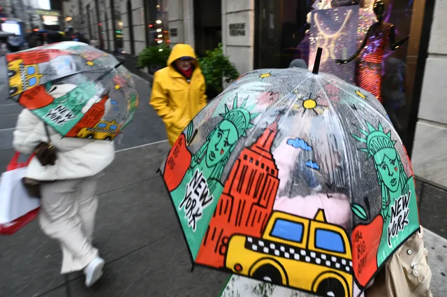 People hold matching umbrellas as they walk down Fifth Avenue in strong winds from a nor'easter while walking down Fifth Avenue in New York, New York, September 26, 2026.