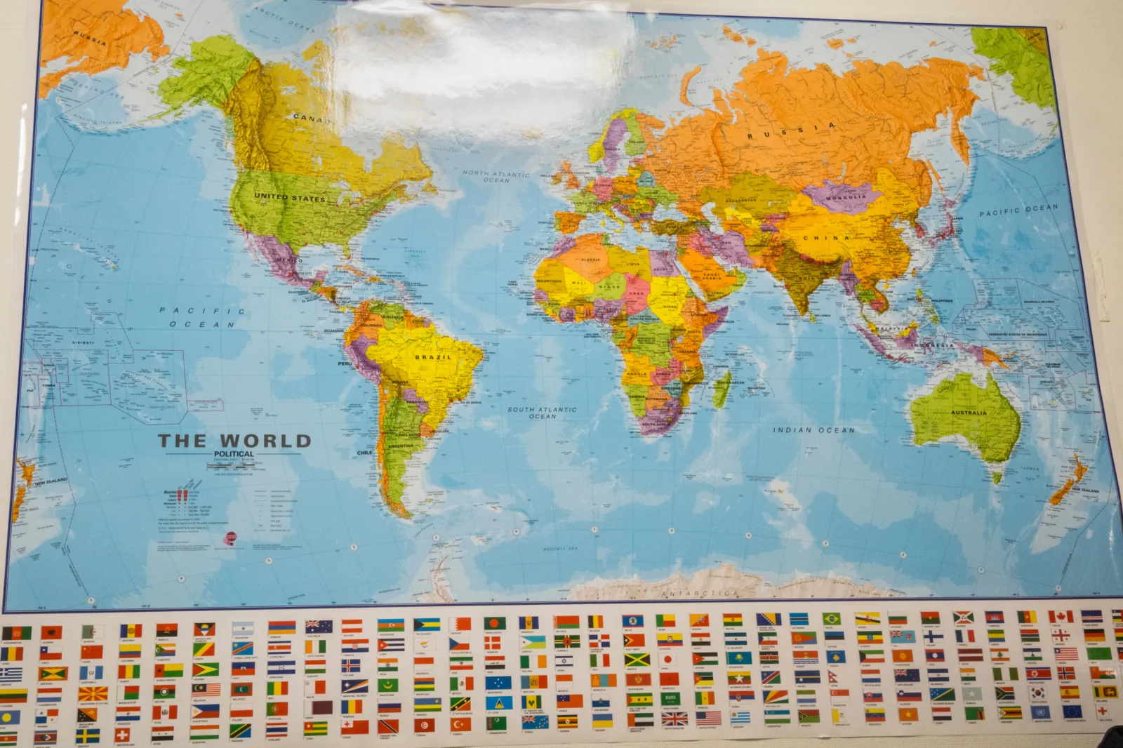 Man in front of world map on wall - stock photo
