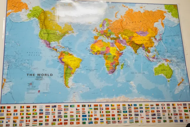 Man in front of world map on wall - stock photo