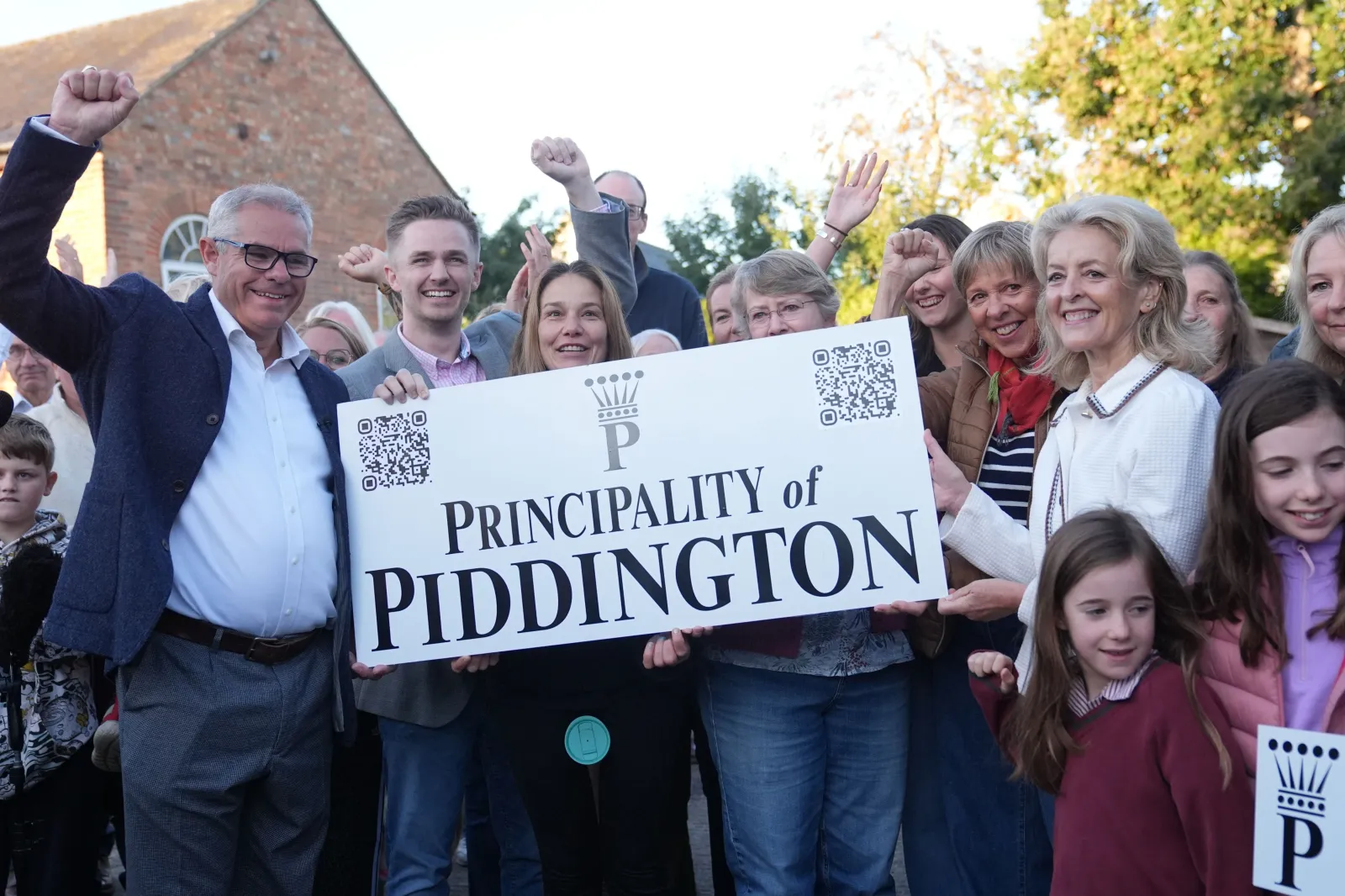 Residents pose with a "Principality of Piddington" sign after they voted overwhelmingly on September 15 to become independent from the U.K. in a symbolic vote.