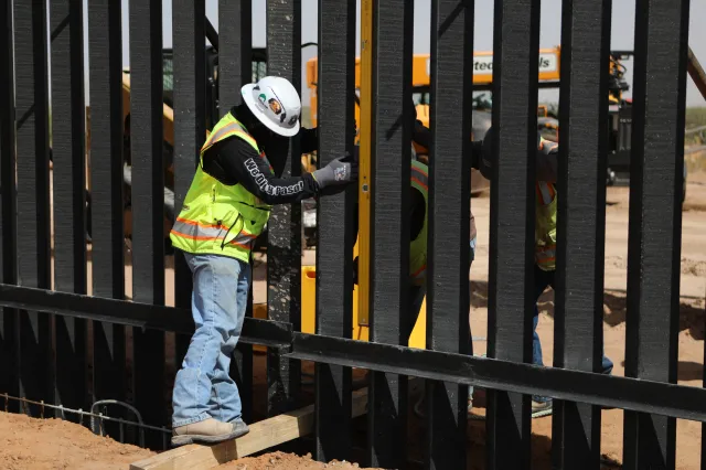 A U.S. worker is seen from Ciudad Juárez, Mexico, adjusting panels more than nine meters (30 feet) tall as part of the new black-painted border wall between the United States and Mexico, at the border between Santa Teresa, United states, and Ciudad Juarez, Mexico, on August 5, 2026.