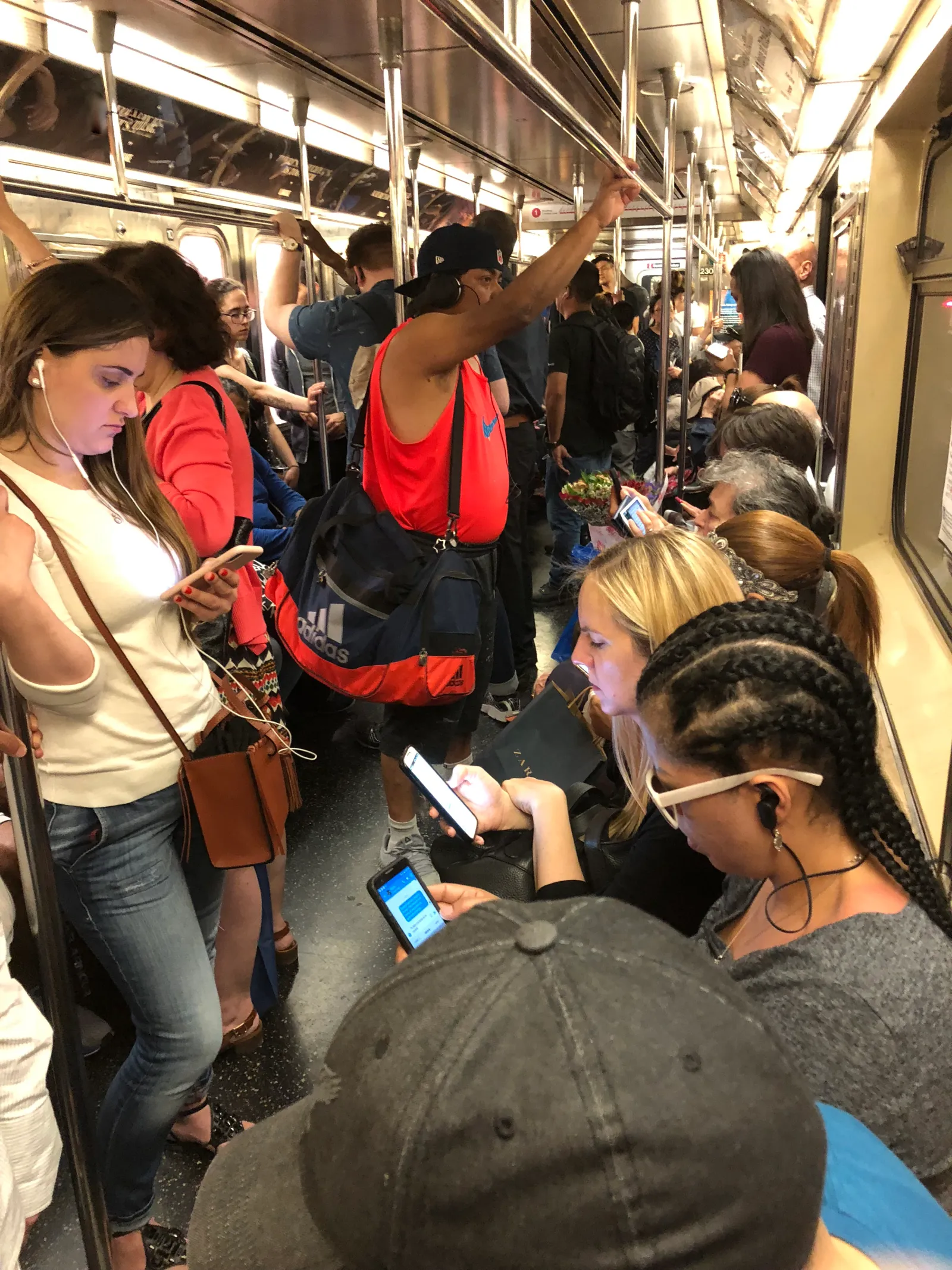 People on their cellphones on the New York City subway