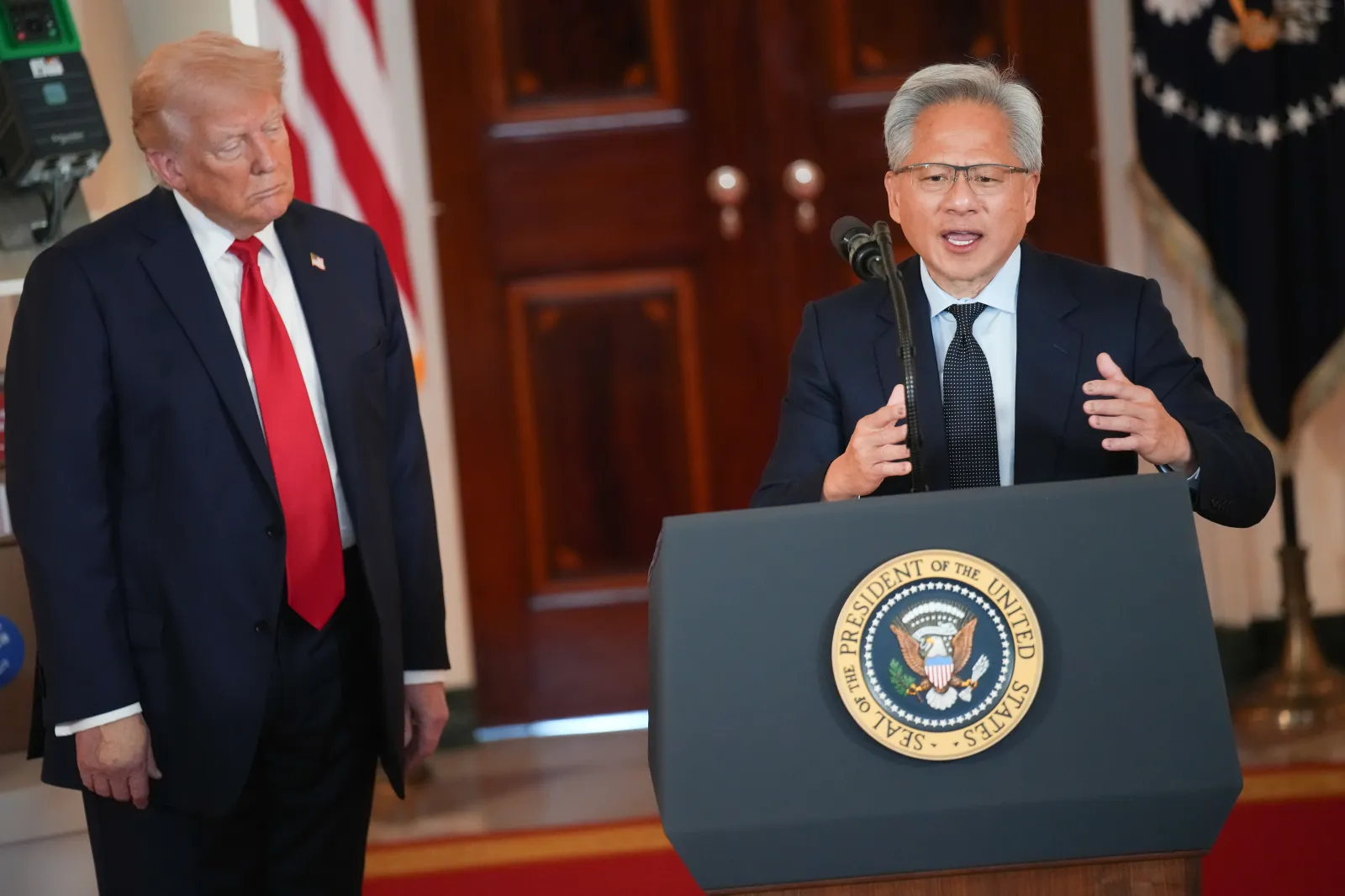 U.S. President Donald Trump listens as Nvidia CEO Jensen Huang speaks in the Cross Hall of the White House during an event on "Investing in America" on April 30