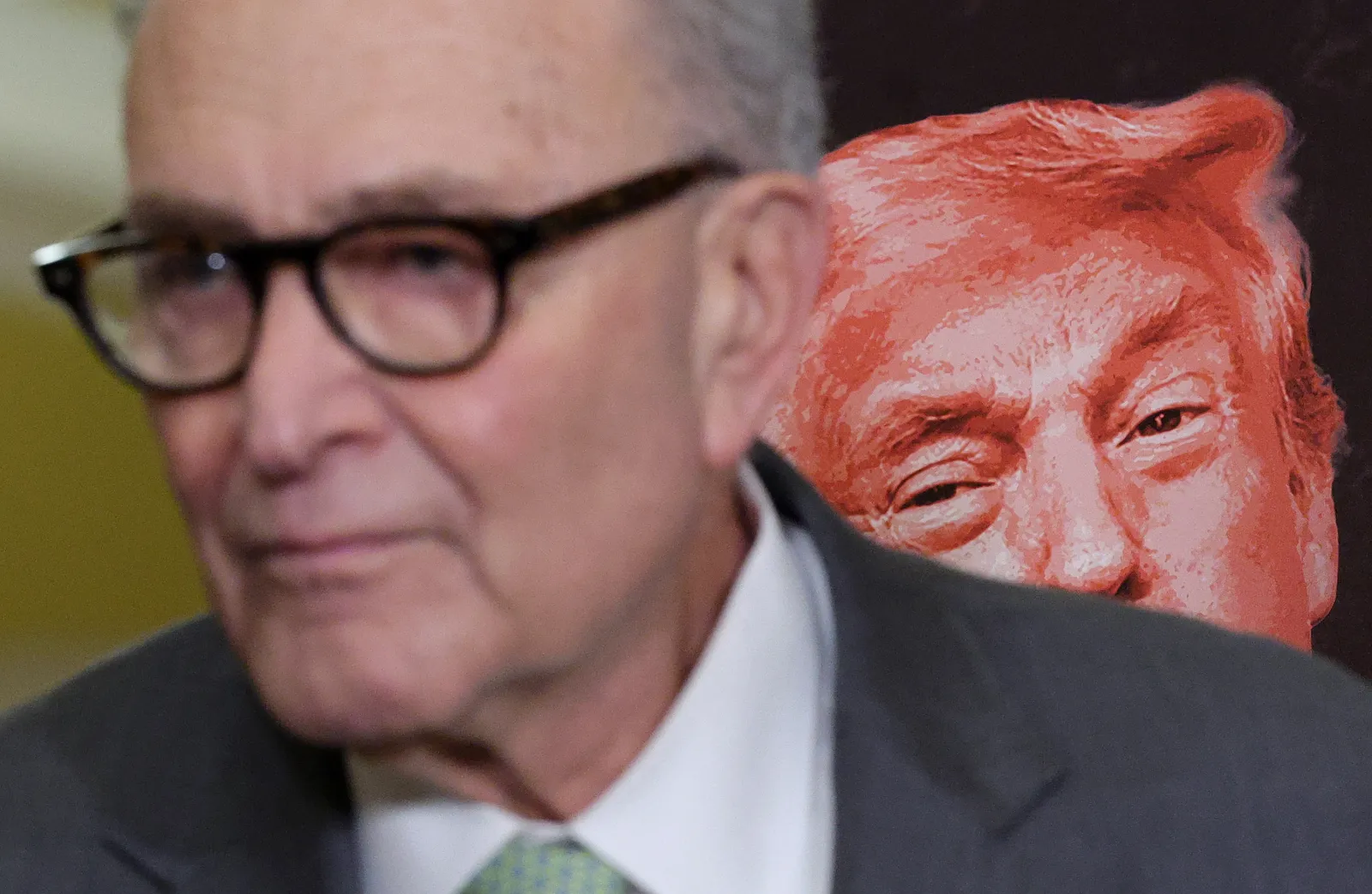Senate Minority Leader Chuck Schumer, a New York Democrat, speaks alongside a poster of President Donald Trump on March 3 at the U.S. Capitol in Washington, D.C