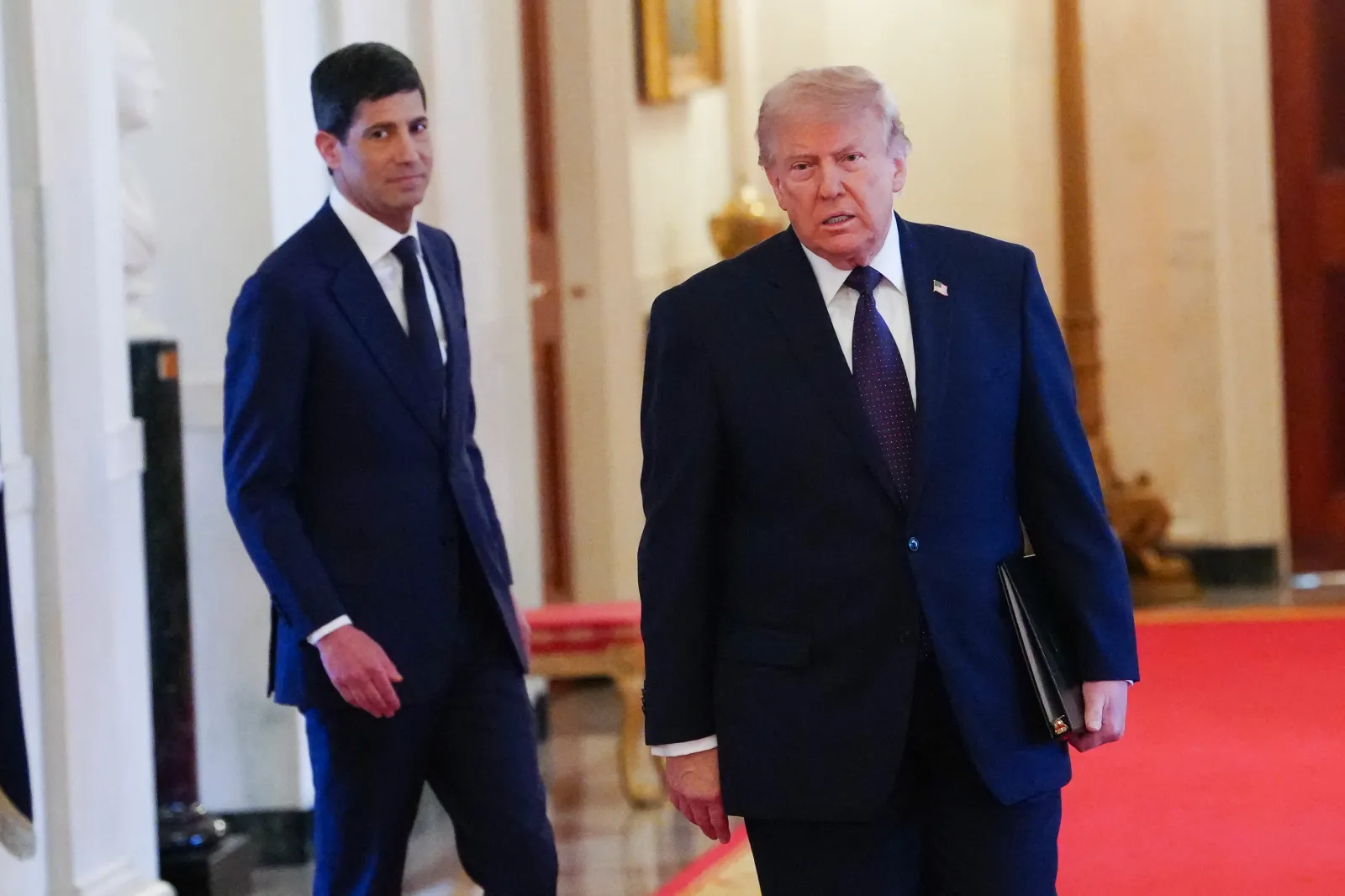 President Donald Trump joined by the new Chairman of the Federal Reserve Kevin Warsh (L), arrives in the East Room of the White House during a swearing in cerem