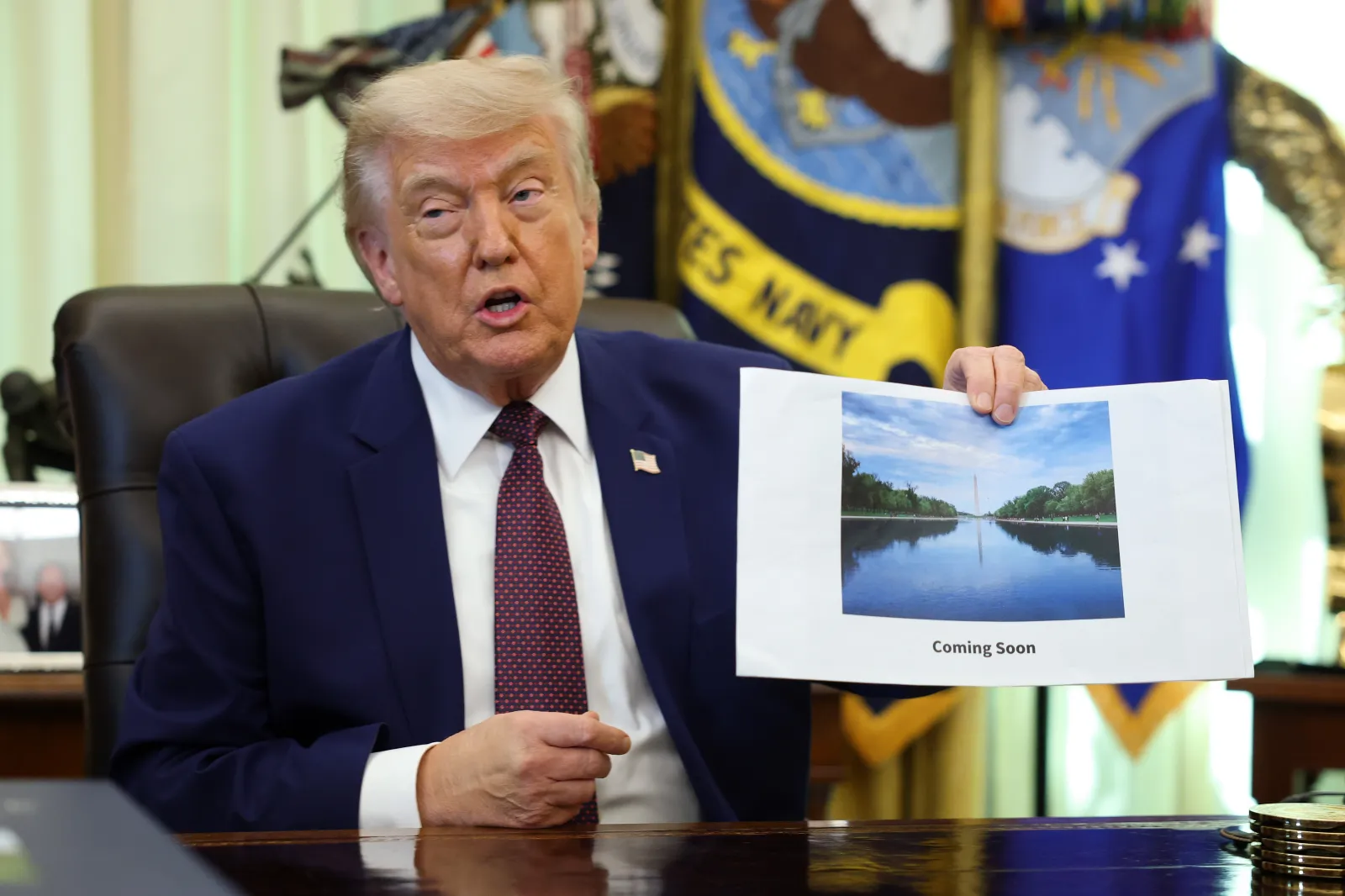President Donald Trump displays a rendering of his proposed renovations to the Lincoln Memorial Reflecting Pool during an event in the Oval Office of the White
