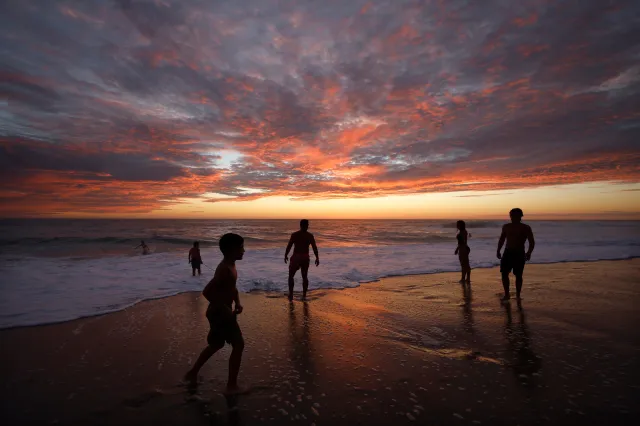 Beachgoers stand on the coastline of La Jolla's Windansea Beach at sunset on a hot and humid summer day as large surf generated by Hurricane Marie slams the Southern California coast on September 5, 2026 in San Diego, California.
