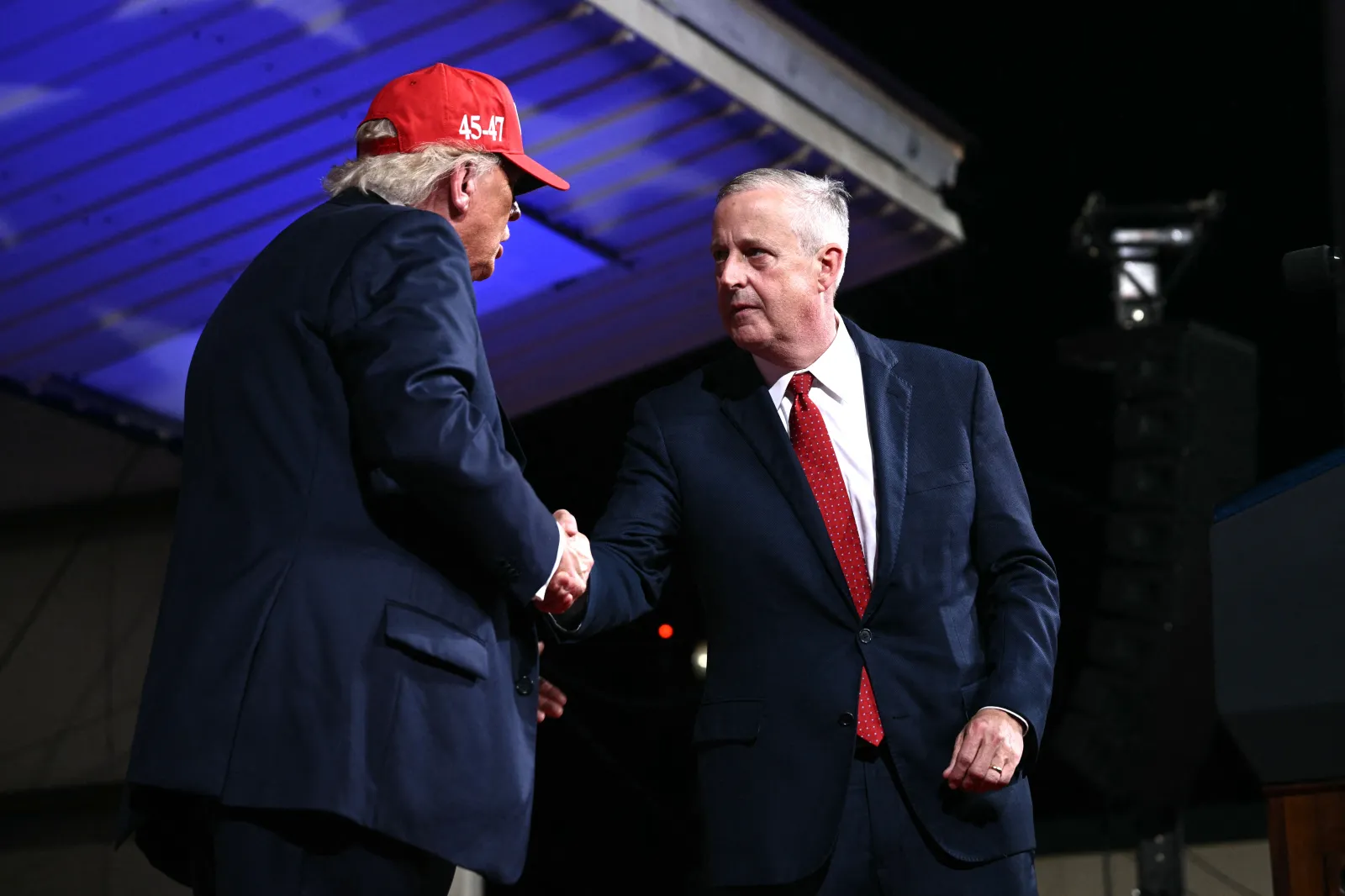US President Donald Trump shakes hands with Republican US Senate candidate Michael Whatley (R) during a rally at Gastonia Municipal Airport in Gastonia, North C