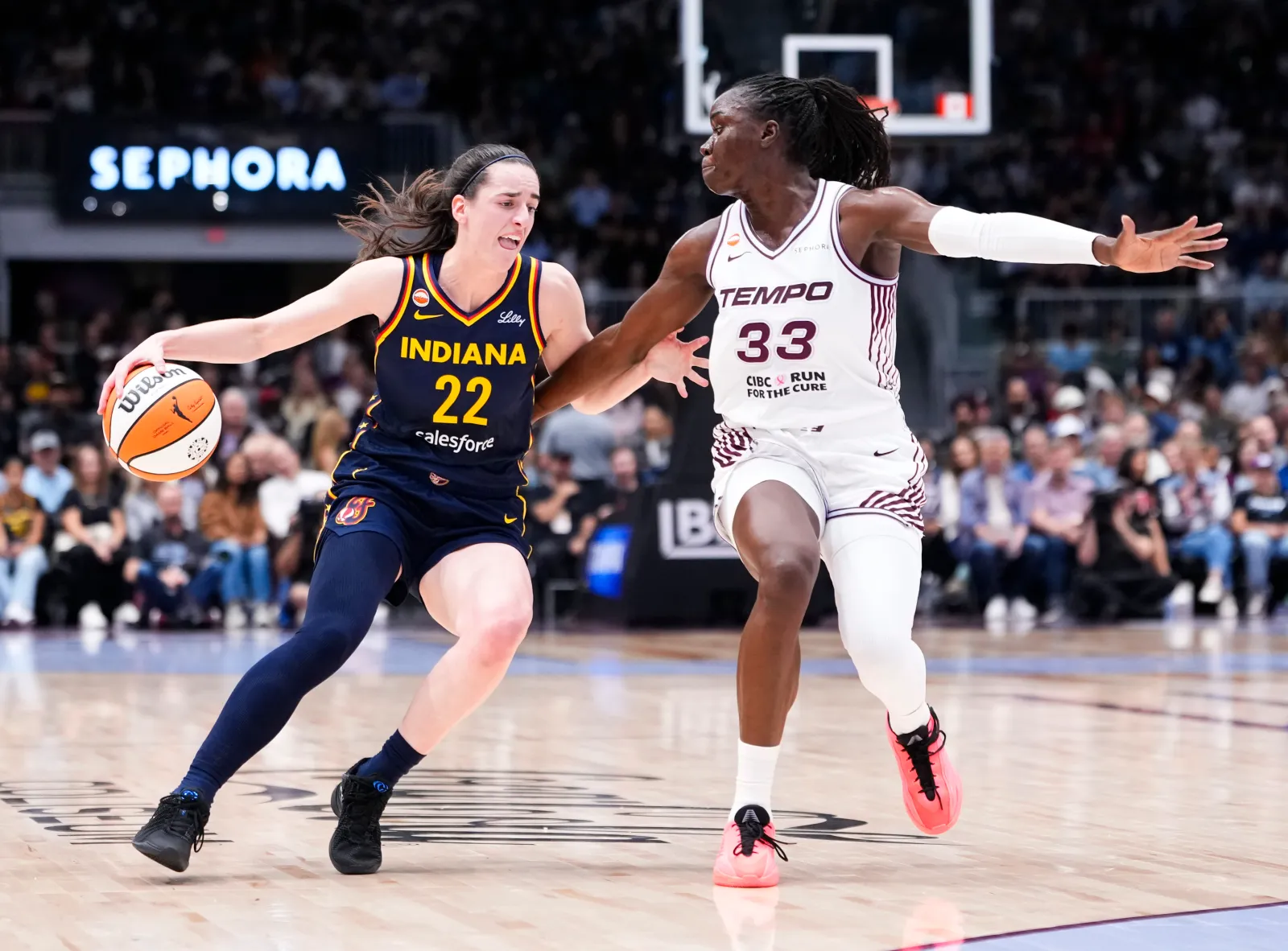 Indiana Fever star Caitlin Clark dribbles against the Toronto Tempo's Ornella Bankole