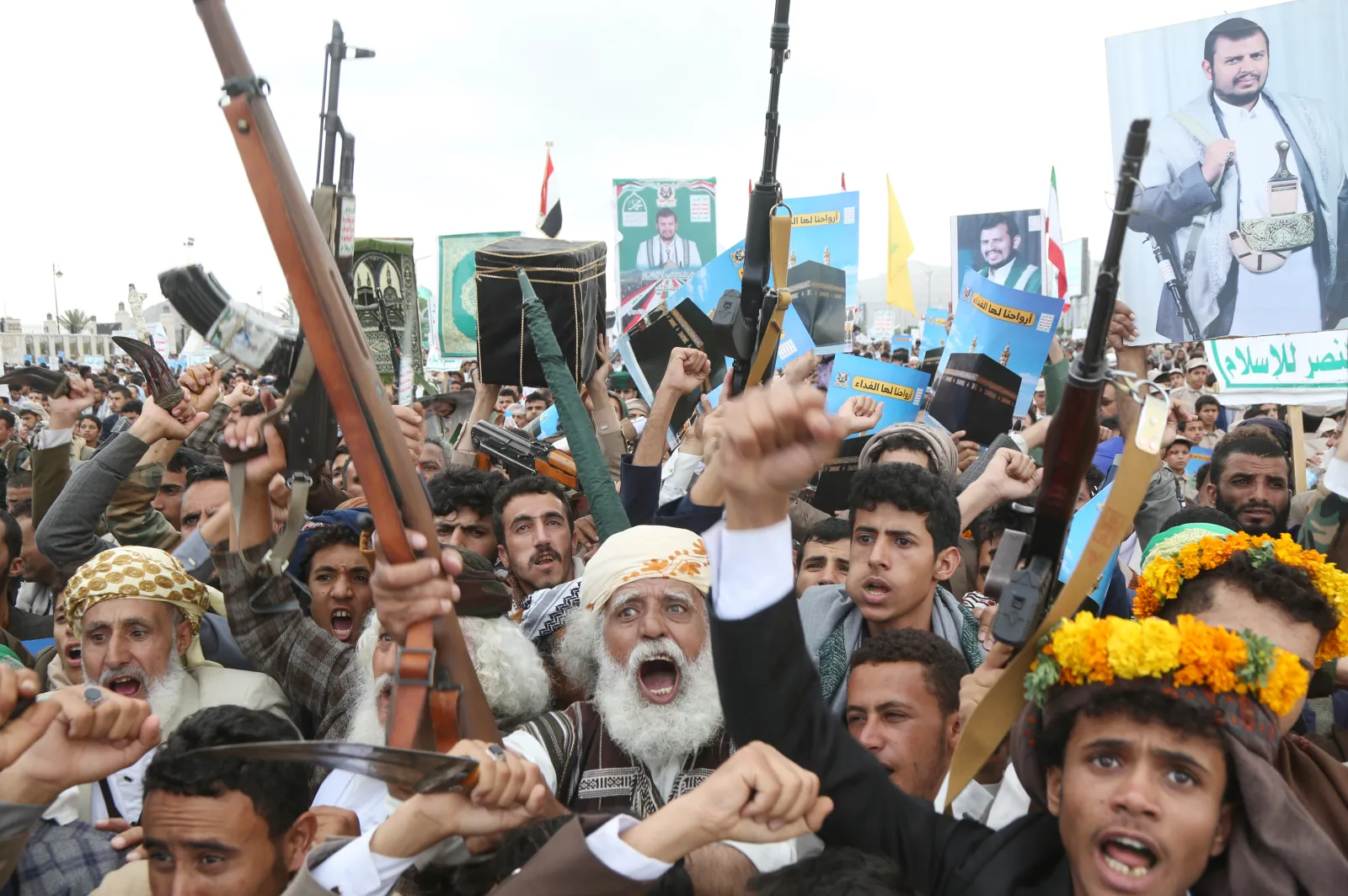 Yemenis loyal to Ansar Allah brandish weapons and images of leader Abdul Malek al-Houthi during a demonstration against Saudi accusations that the group was pre