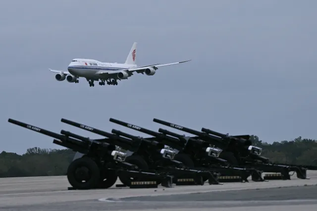 An Air China plane carrying Chinese President Xi Jinping descends before U.S. ceremonial artillery toward Joint Base Andrews in Maryland on Wednesday.