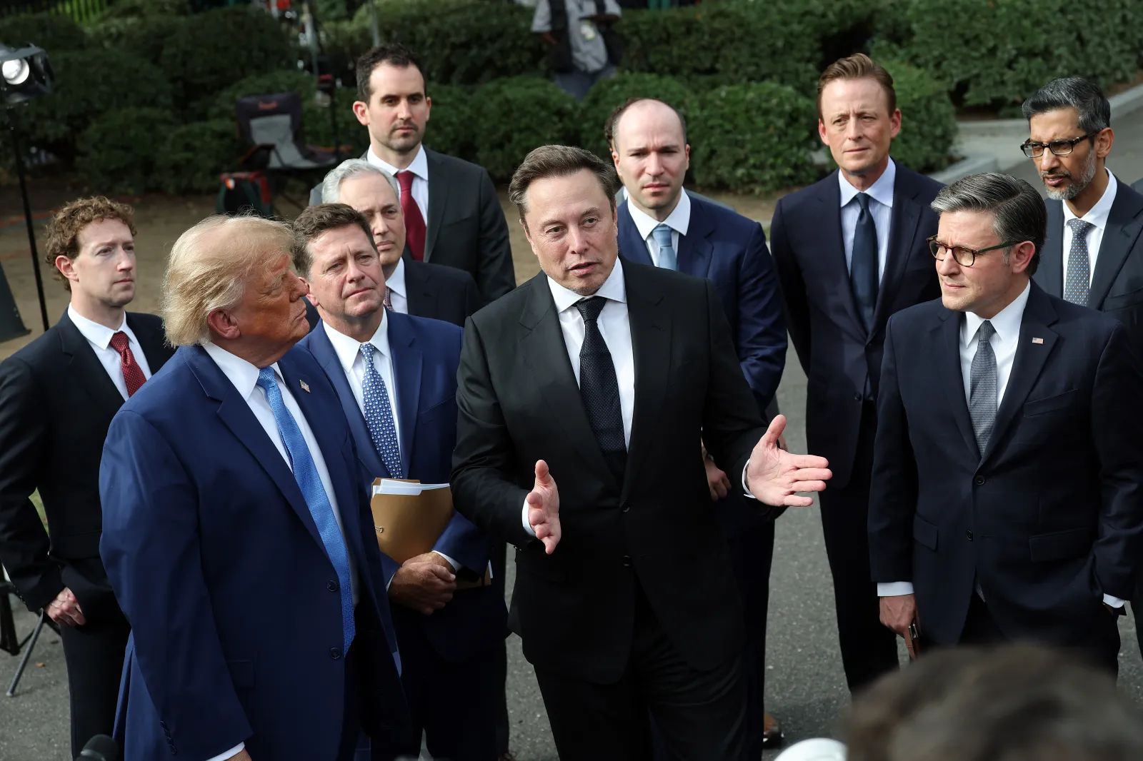 Elon Musk stands with President Donald Trump, Mark Zuckerberg, Mike Johnson and others at a press briefing after a meeting on artificial intelligence outside the West Wing of the White House on Tuesday in Washington, D.C. (Photo by Kevin Dietsch/Getty Images)