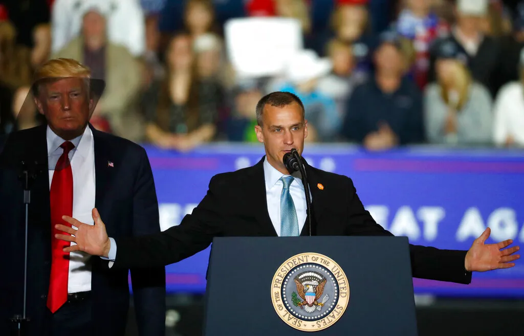 President Donald Trump, left, watches as Corey Lewandowski, right, his former campaign manager for Trump's presidential campaign, speaks during a campaign rally in Washington Township, Mich. (AP Photo/Paul Sancya, File)