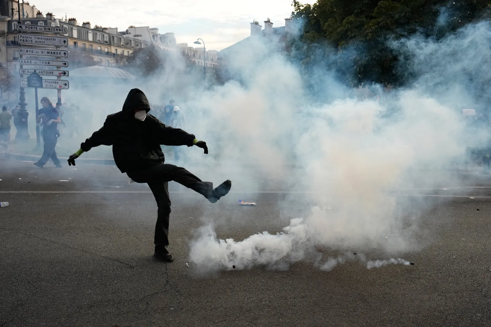 A protester kicks a tear-gas canister during scuffles following a demonstration against underresourced schools, in Paris, on October 6.