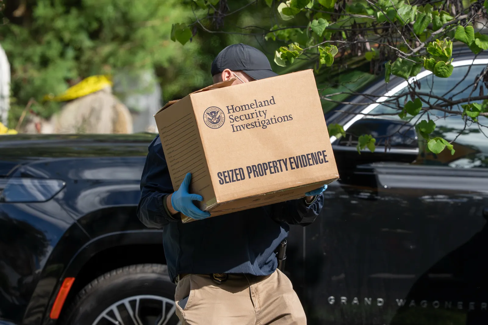 A Homeland Security Investigations officer carries a box seized from the Washington, D.C.-area home of Democratic Congresswoman Ilhan Omar during a federal raid on October 12. (AP Photo/J. Scott Applewhite)