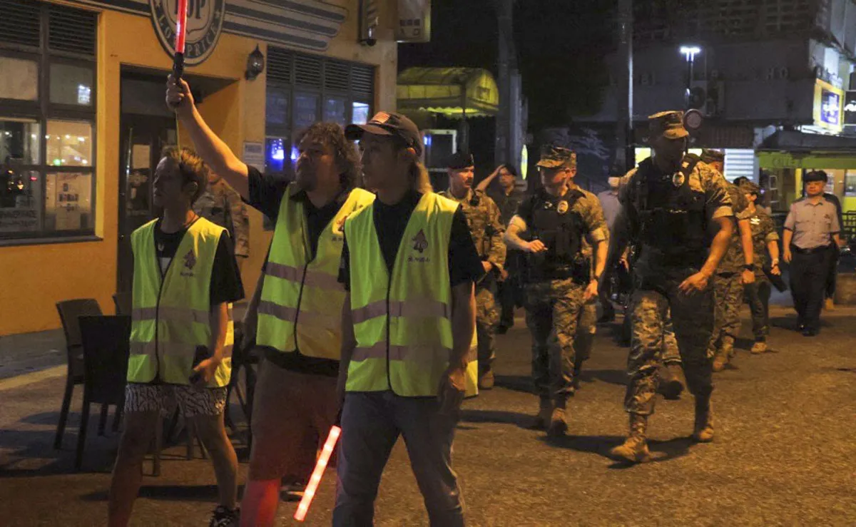 Okinawa police and U.S. military police patrol jointly with local volunteers in the city of Okinawa on the night of Oct. 9, 2026, following the arrest of a U.S. Marine over the suspected robbery and murder of a resident of the southern island prefecture.