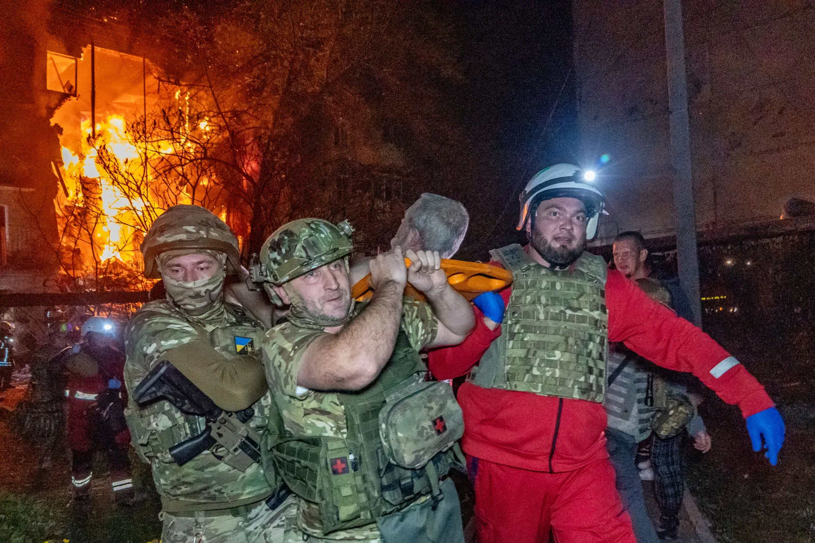 Rescuers evacuate an injured civilian after a residential building was hit following a Russian air attack, Kharkiv, Ukraine, October 13, 2026.