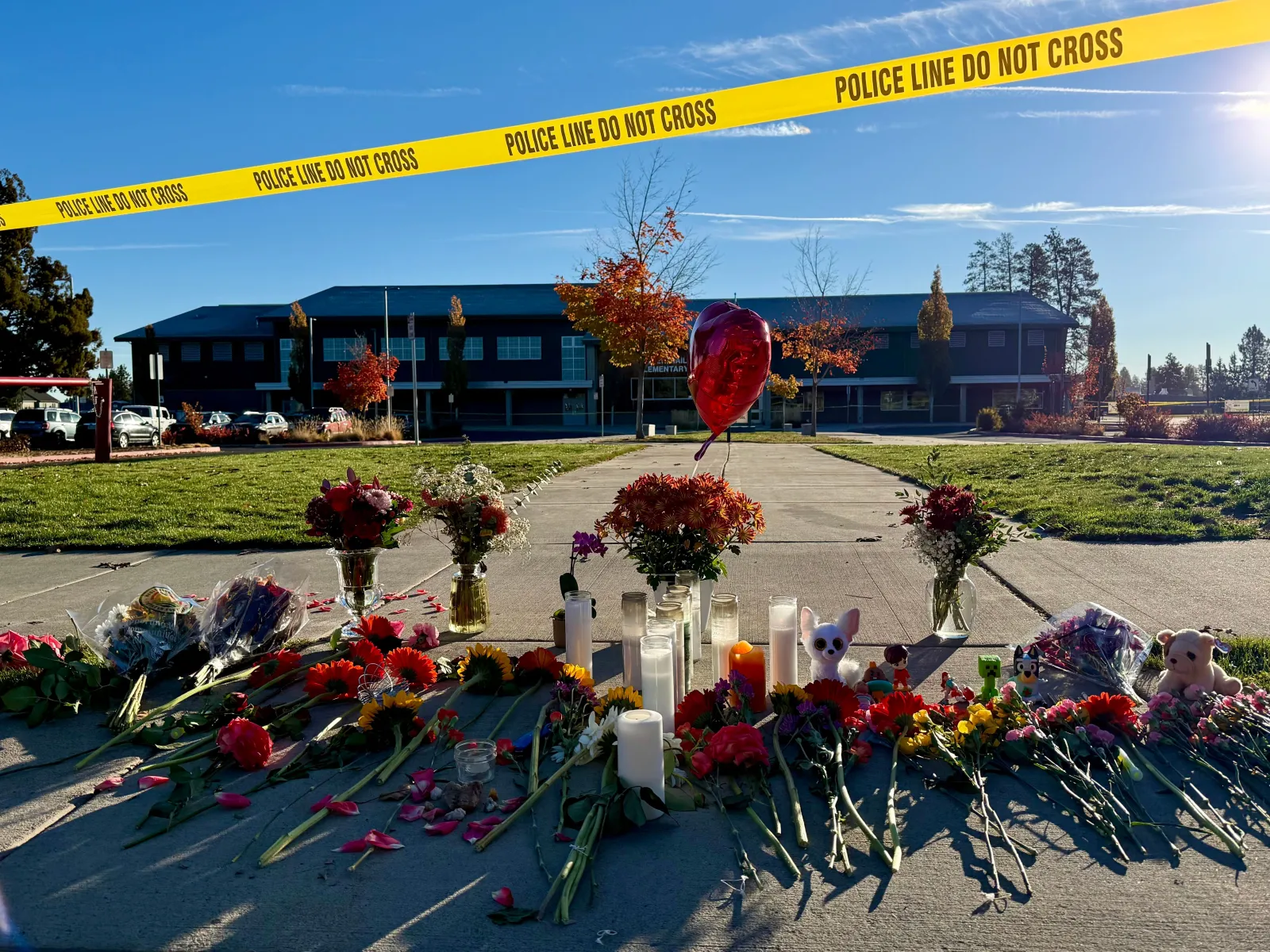 Flowers and candles are placed at a makeshift memorial at Silver Rail Elementary School in Bend, Ore., on Friday, Oct. 16, 2026, a day after a deadly shooting. (AP Photo/Haven Daley)