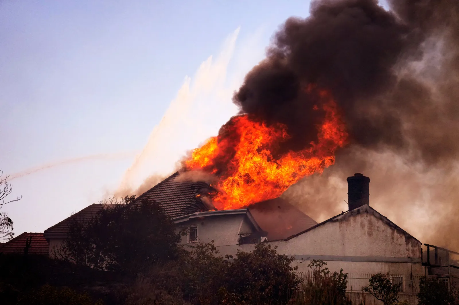 A roof engulfed in flames is seen during the Norte Fire on Friday, October 16, 2026, in San Juan Capistrano, California.