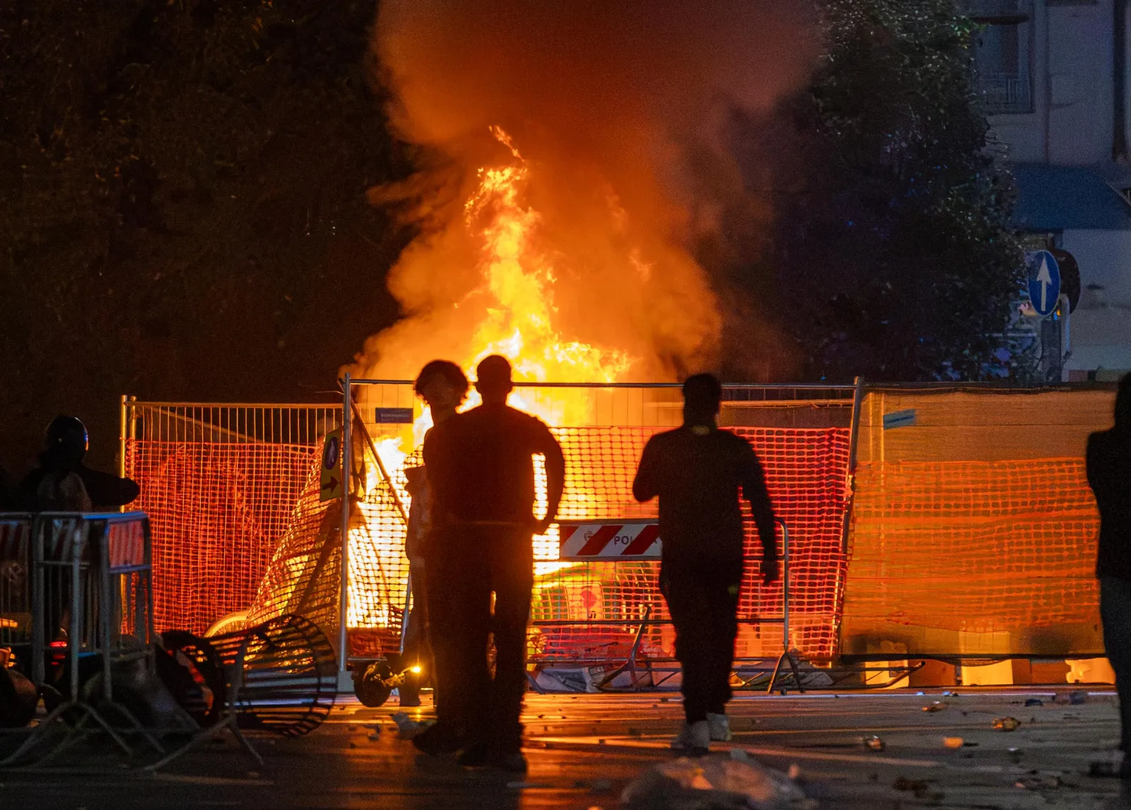 A fire burns following clashes between police and "Italia in Piazza" protesters in front of the Milan Cathedral in Milan on October 17.