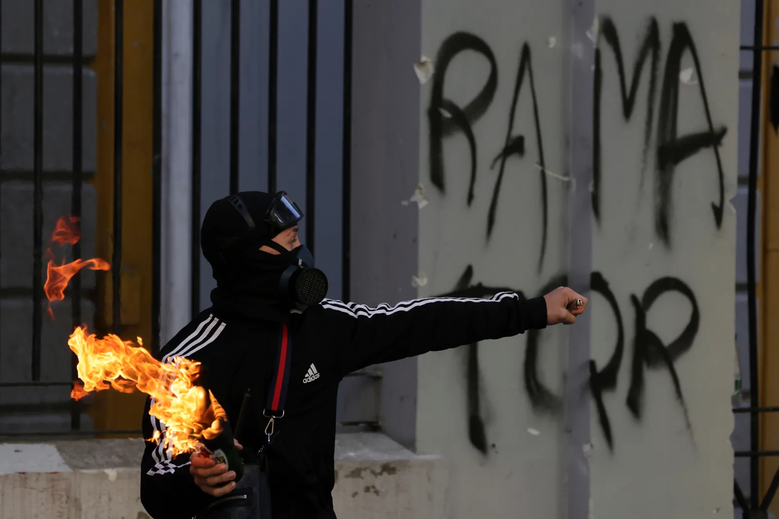 A protester prepares to throw a petrol bomb toward riot police during clashes at an anti-government demonstration in Tirana, Albania, on October 18.