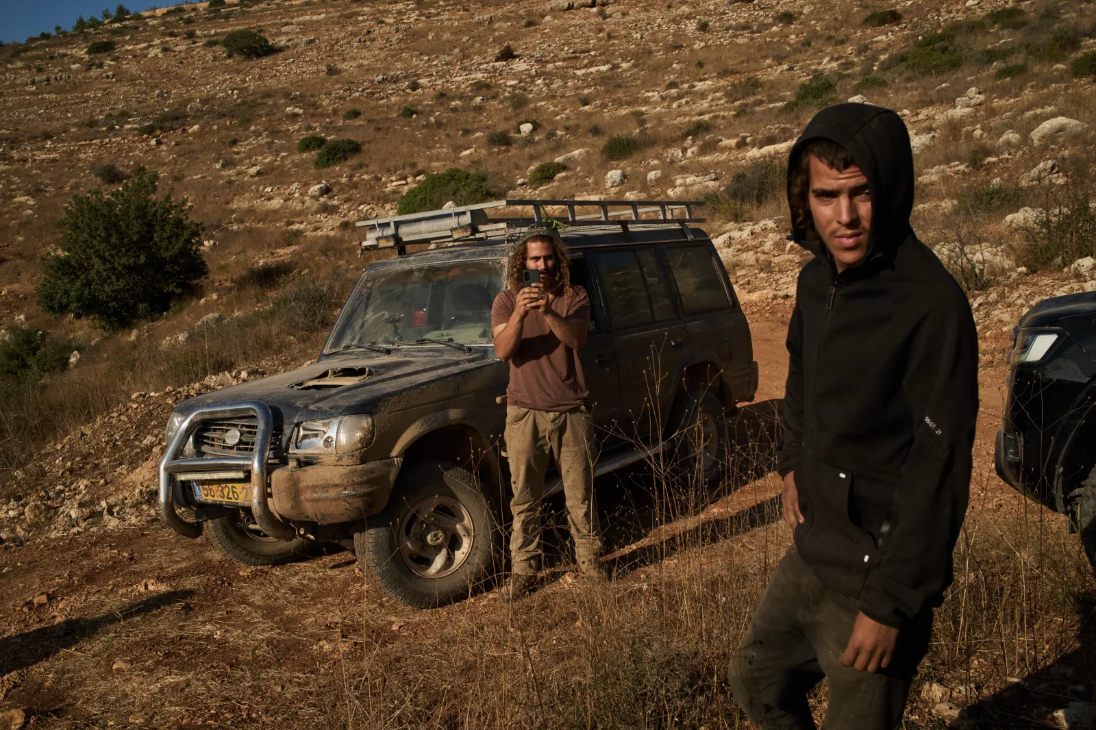 Israeli settlers block a road before Palestinians are prevented from continuing to harvest olives in the West Bank village of Deir Abu Mashal on Monday.