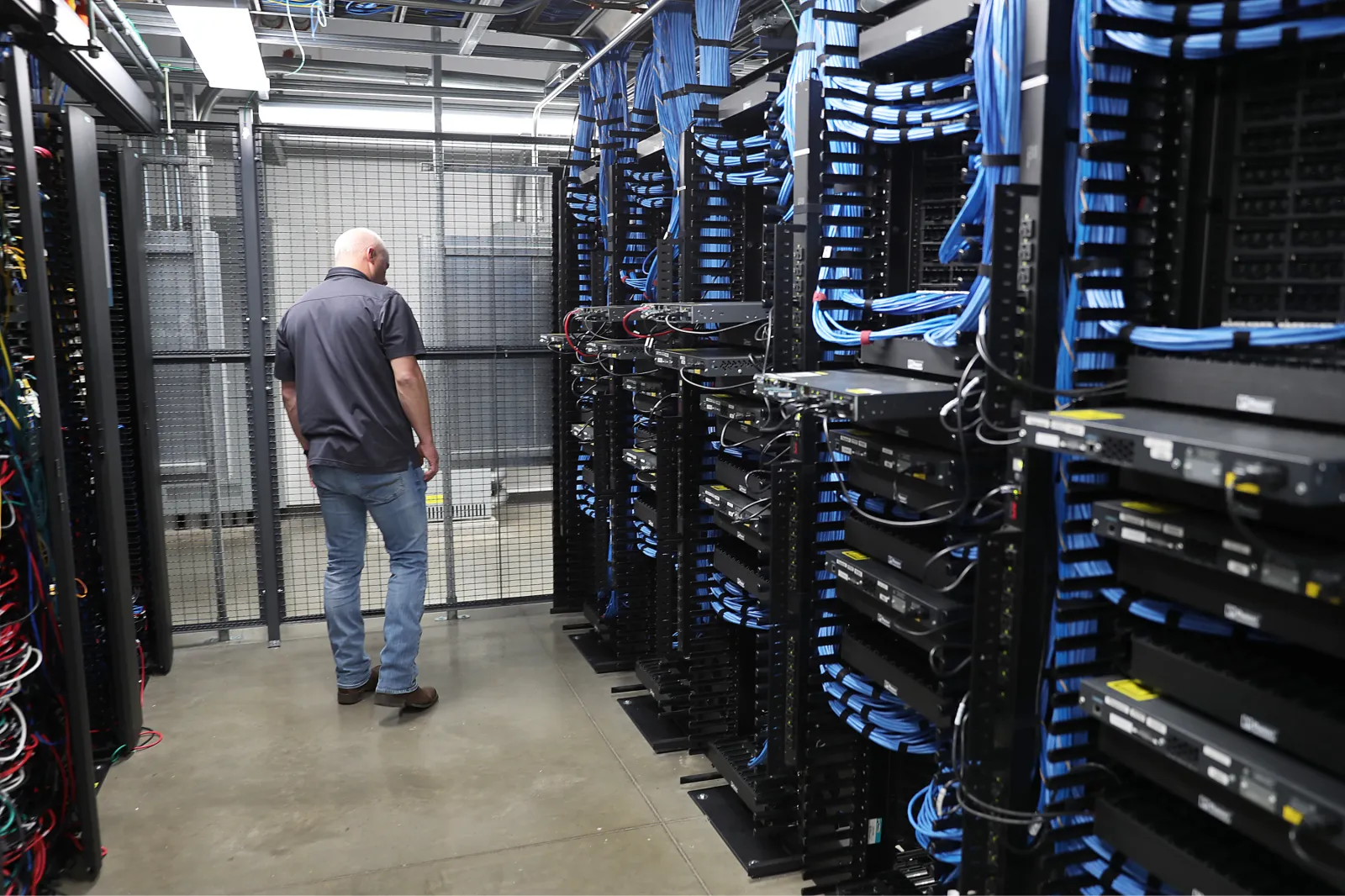 A man inspects racks and network switches at a data center in Altoona, Iowa, on October 15, 2019.