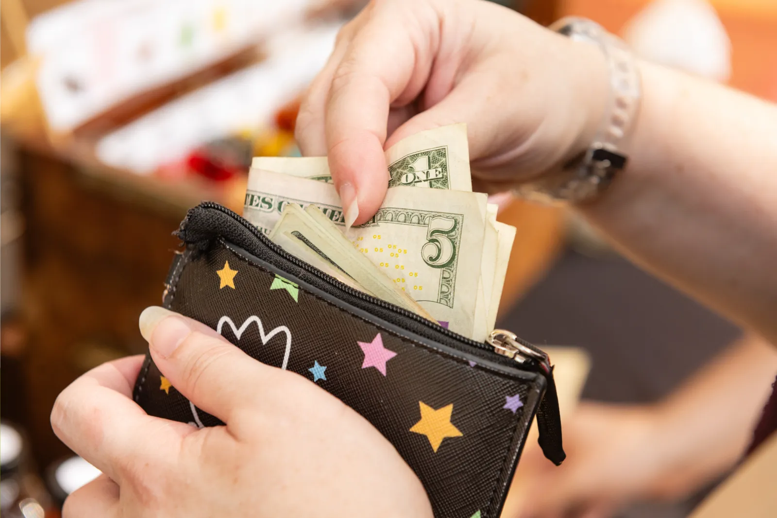 Stock photo: Woman pulls money out of a wallet.