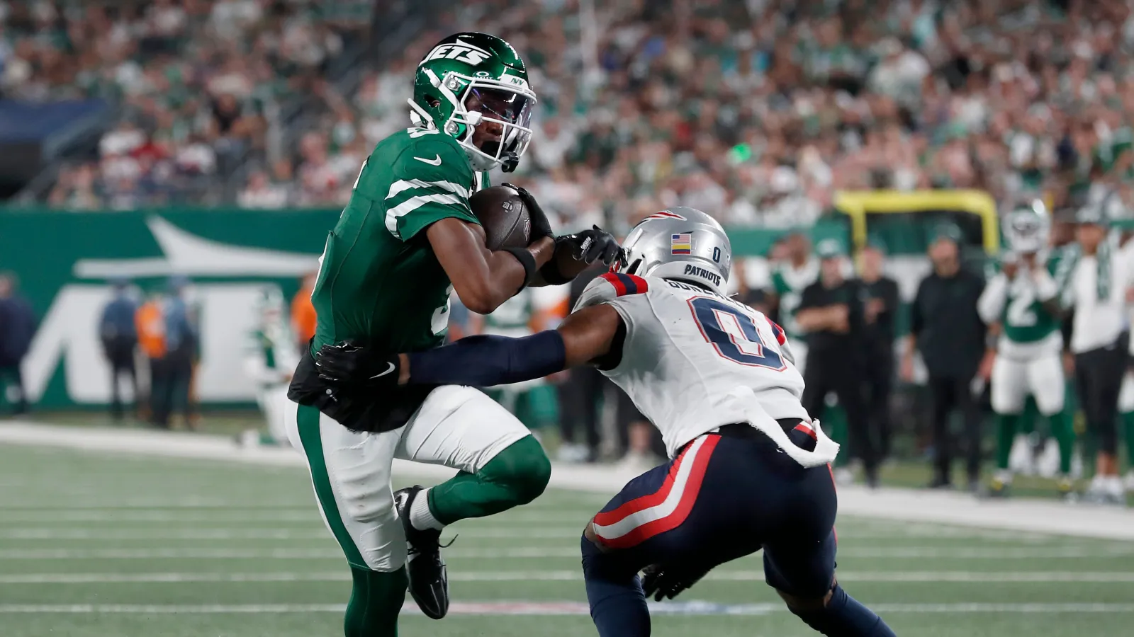 Garrett Wilson #5 of the New York Jets in action against Christian Gonzalez #0 of the New England Patriots