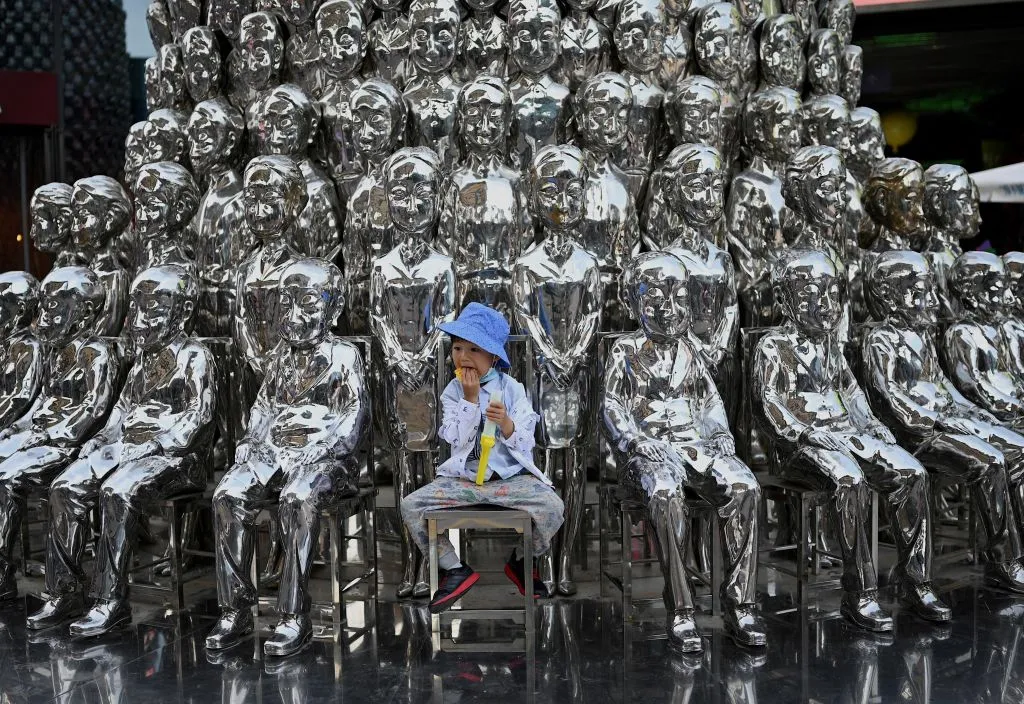A boy sits on a chair among sculptures on display at a shopping center on International Children's Day in Beijing on June 1, 2021, a day after China announced it would allow couples to have three children.