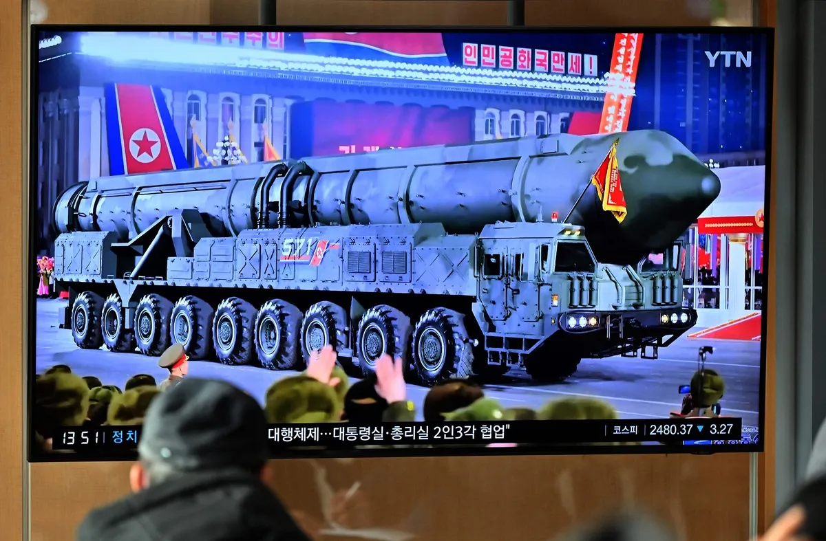 A man watches a television screen showing a news broadcast of a North Korean military parade in Pyongyang at a railway station in Seoul, South Korea, on February 9, 2023.