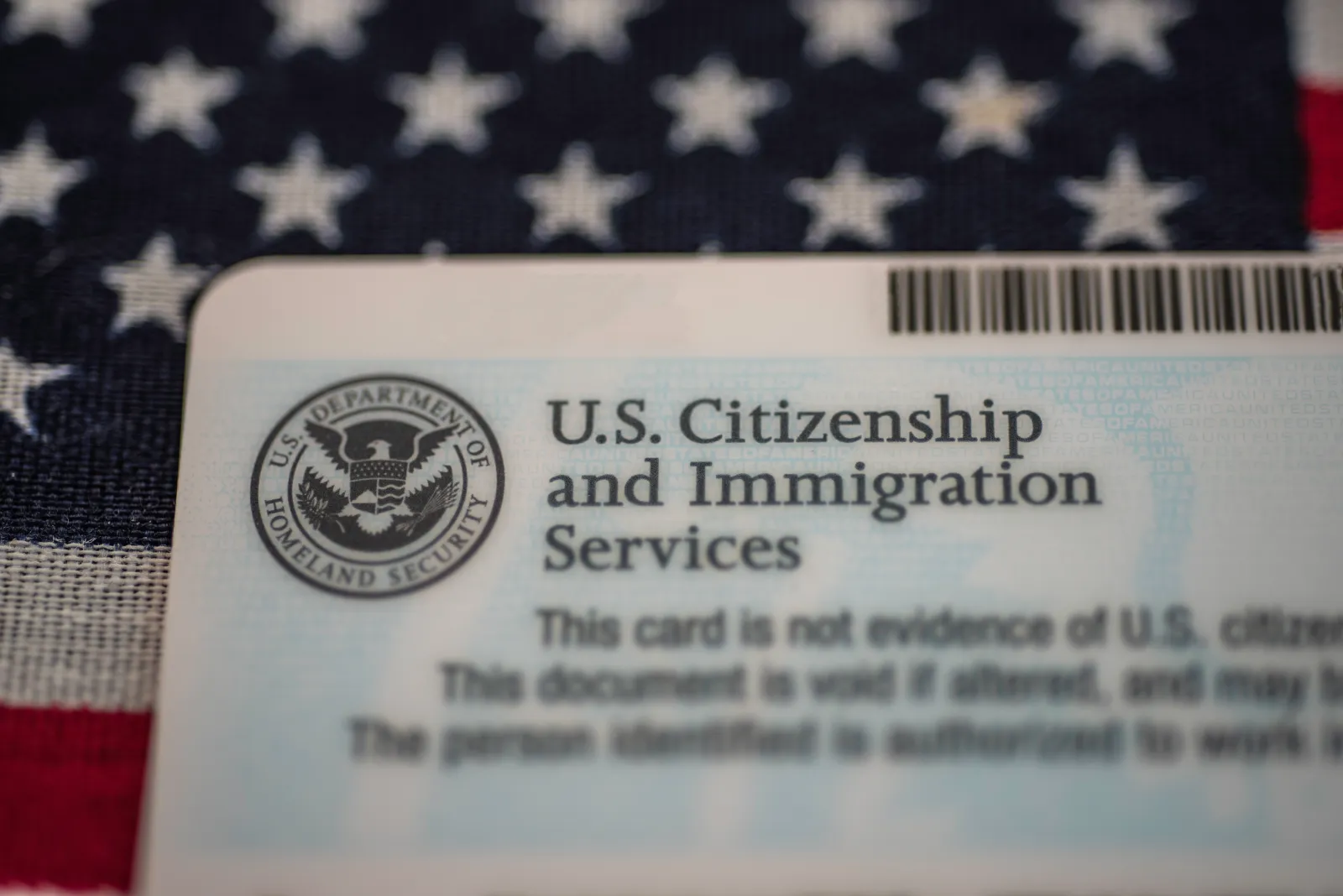 Washington, D.C., USA - July, 16, 2018: Back side of employment (work) authorization card by U.S. Citizenship and Immigration Services (USCIS) on American flag background.
