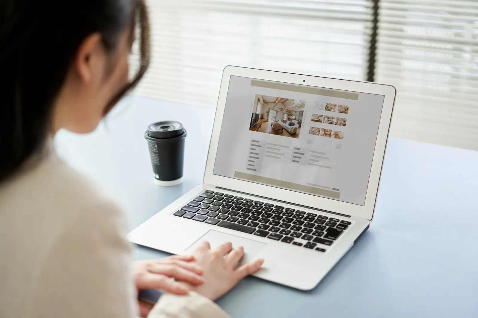 A woman viewing real estate websites on a computer.