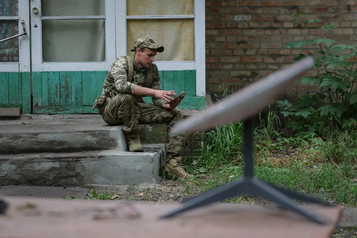 Former prisoner with the call sign "Lyolik" who signed a contract to join the Ukrainian army use mobile to connect to the Starlink at the base of the first assault battalion named after "Da Vinci" on June 15, 2024 in Dnipropetrovsk region, Ukraine.