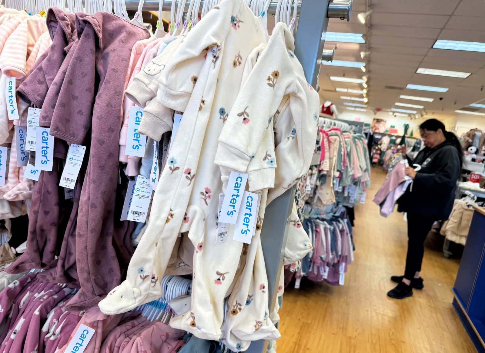 A customer shops at a Carter's Babies and Kids store on November 17, 2025, in Colma, California. Child and baby clothing retailer Carter's is planning to close 150 stores across the country, 50 more than the company had previously stated. All 150 stores will be shuttered by 2028.