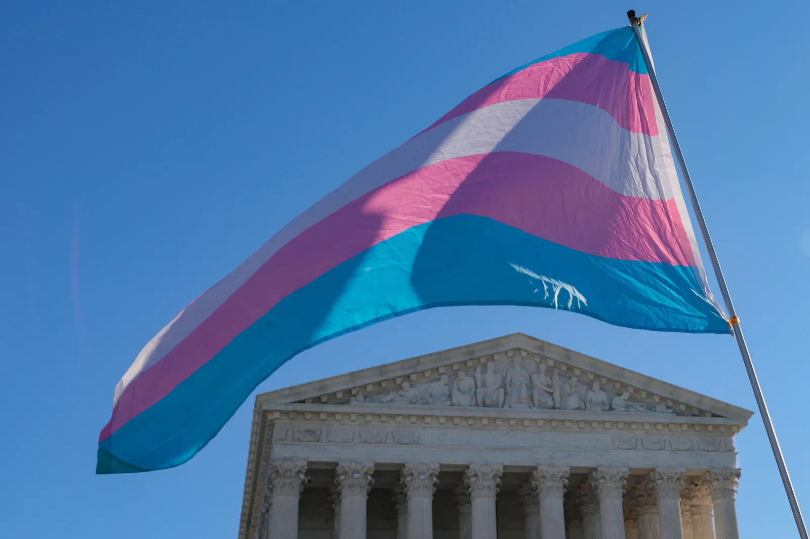 Protesters supporting transgender athletes competing in women's sports wave a transgender pride flag outside the Supreme Court on January 13, 2026 in Washington, DC.