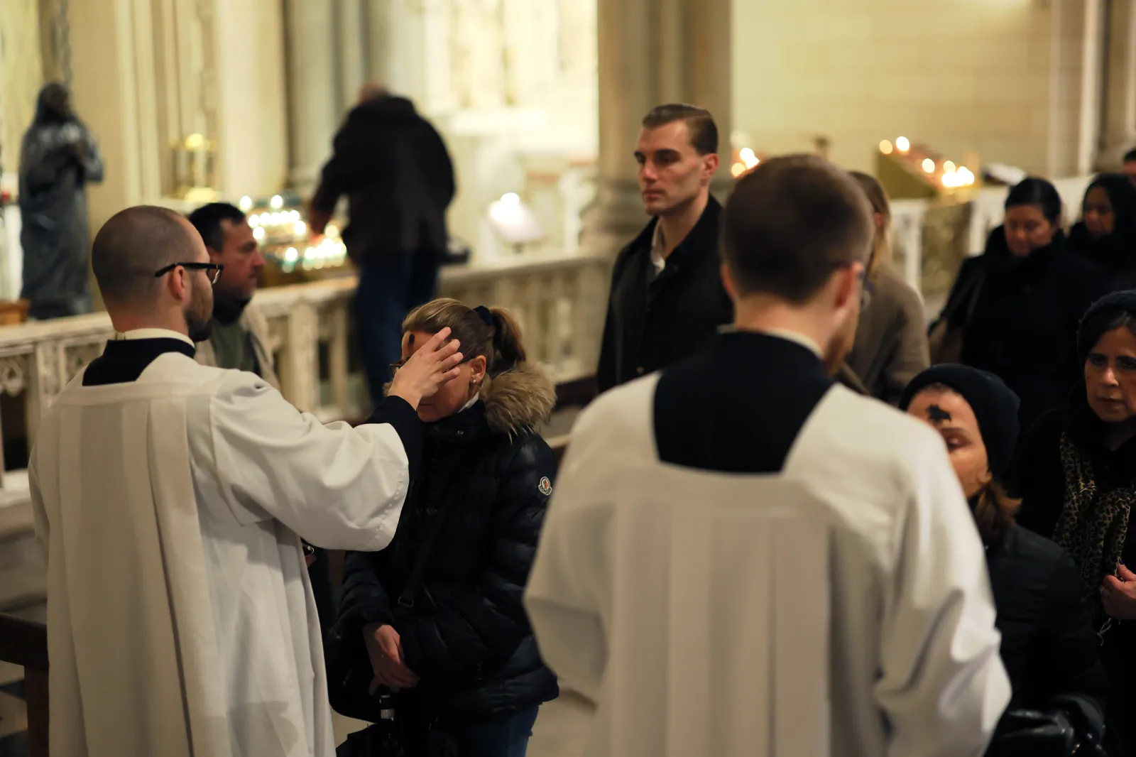 People receive the sign of the cross in ashes on their forehead by a priest at St. Patrick's Cathedral on Ash Wednesday on February 18, 2026, in New York City.