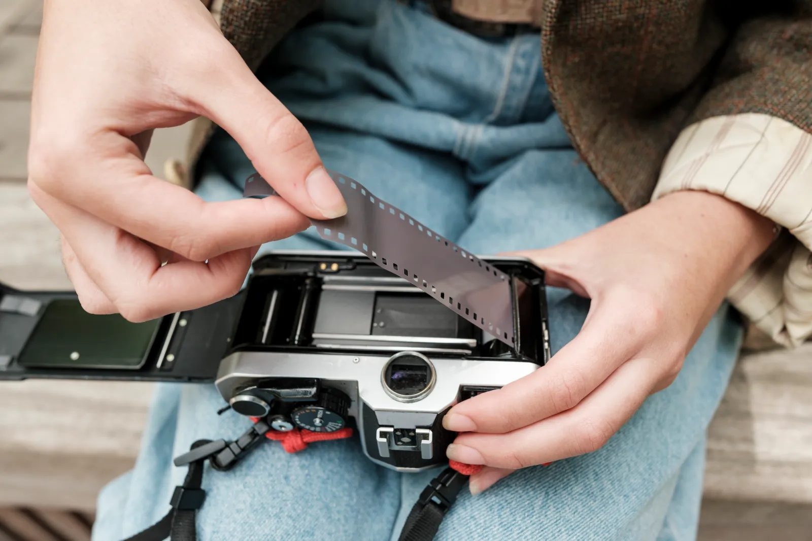 A person loading film into an analog camera.