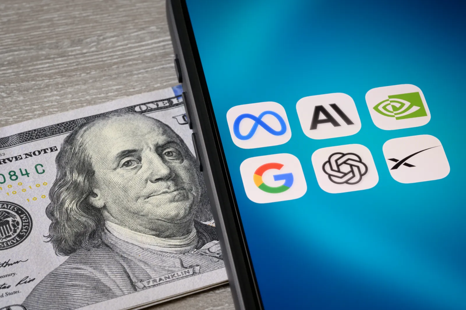 Toronto, ON, Canada - June 23, 2026: MANGOS Meta, Anthropic, NVIDIA, Google, OpenAI, and SpaceX icons shown on a tablet next to some US hundred dollar bills.