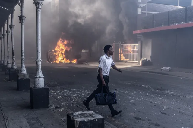 A man runs for cover after clashes erupt between protesters and foreign nationals in Durban, South Africa, on October 8, 2026.