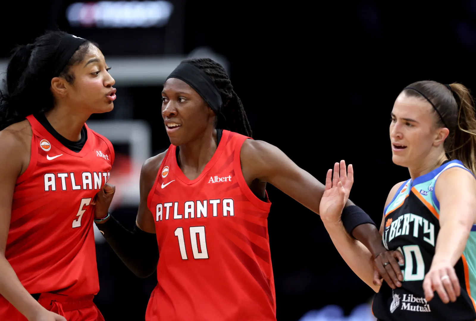 Dream player Rhyne Howard holds Angel Reese back during confrontation with Liberty player Sabrina Ionescu
