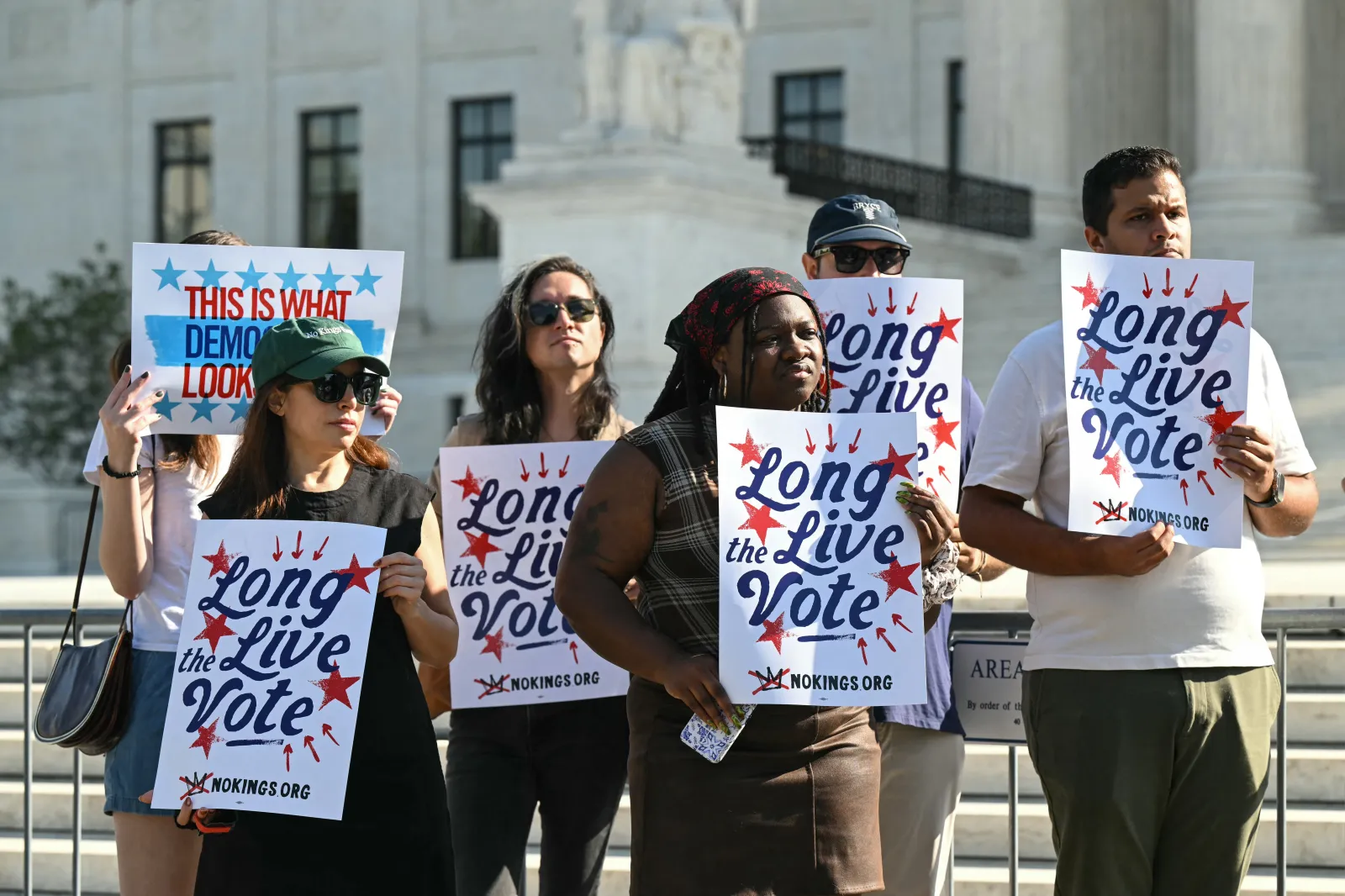 Attendees hold placards outside the Supreme Court in Washington, DC, on October 14, 2026. (Photo by SAUL LOEB / AFP via Getty Images)