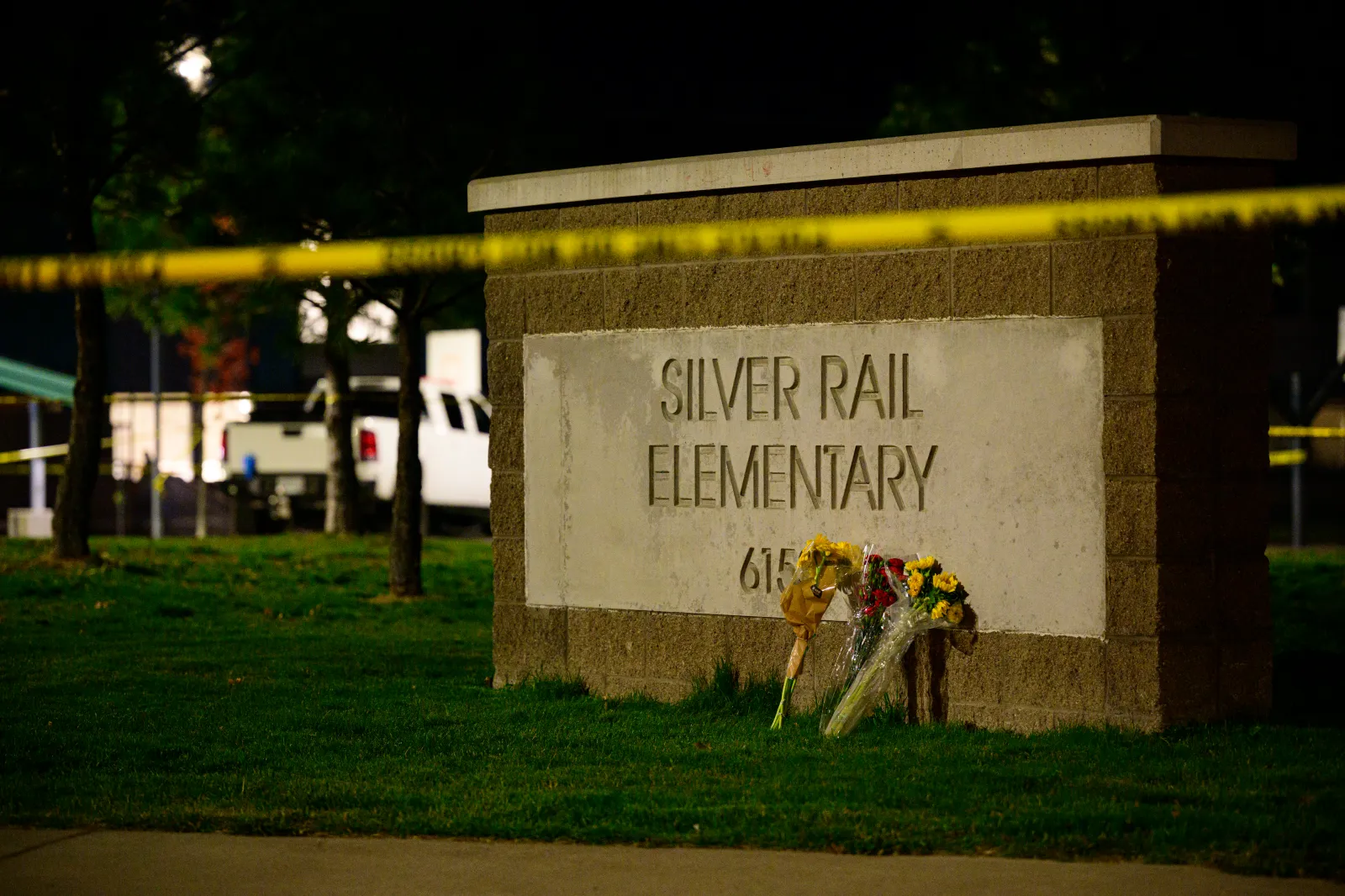 BEND, OREGON – OCTOBER 15: Flowers rest on a sign in front of Silver Rail Elementary School on October 15, 2026 in Bend, Oregon. At least four victims were repo