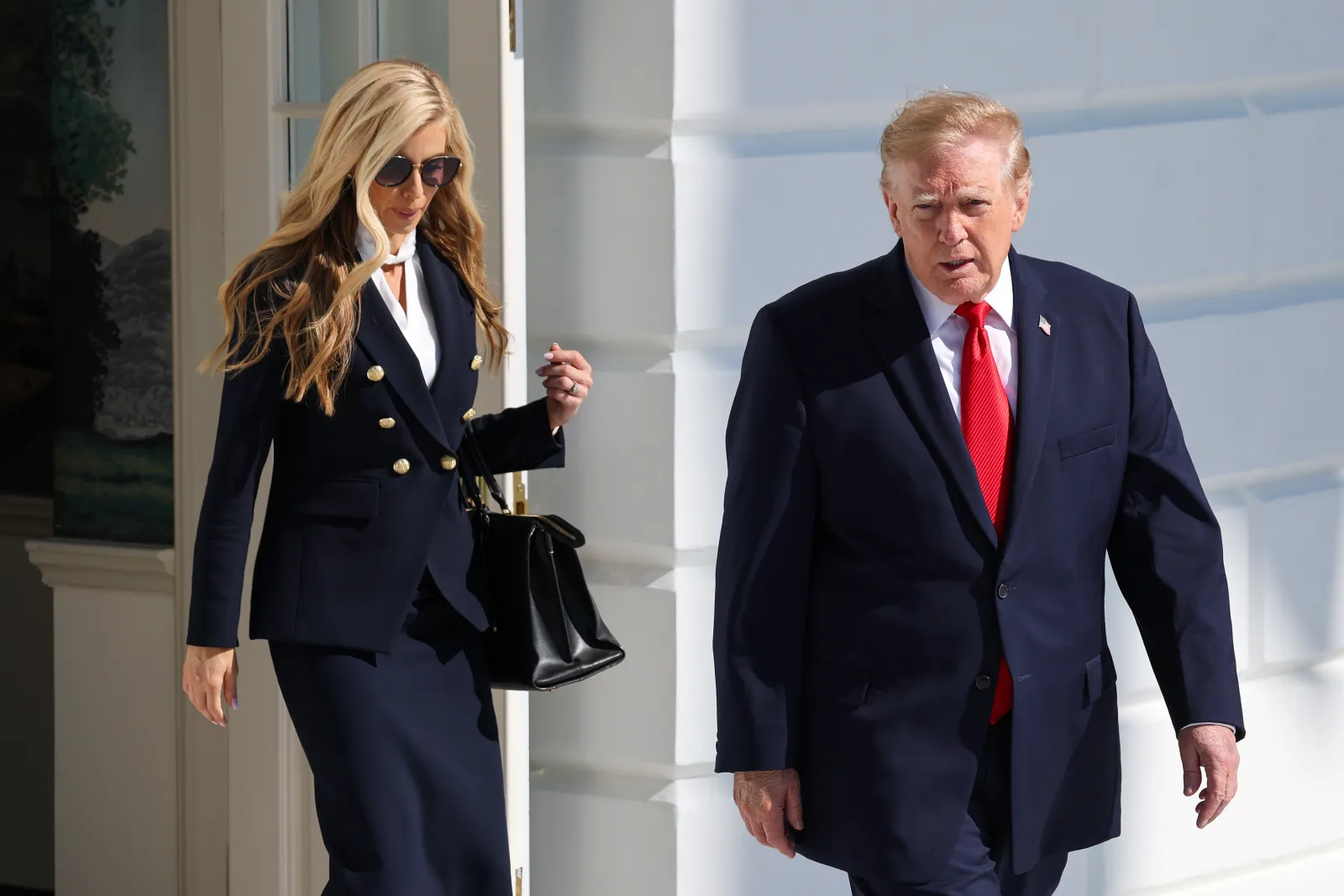 White House press secretary Katie Zacharia (L) walks with President Donald Trump on the White House South Lawn on October 13, 2026.